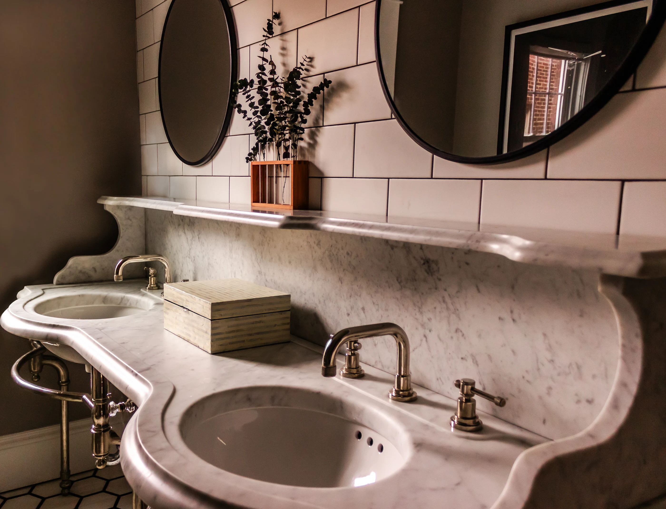 Paired basins and mirrors above the stone vanity at Chevy Chase.