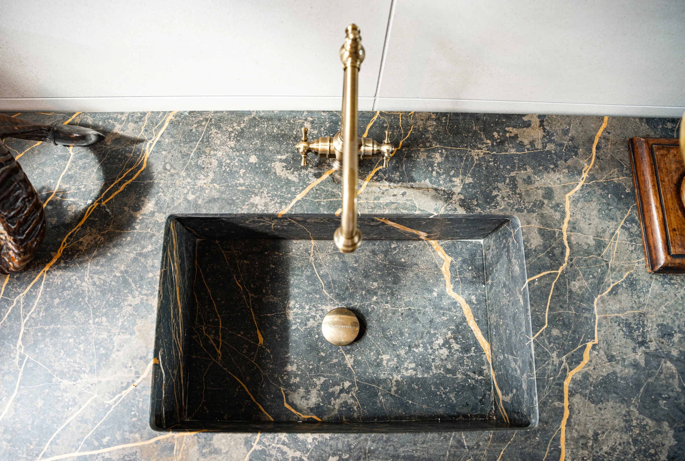 Integrated stone basin with brass faucet in the Cabinet & Stone Lab showroom.
