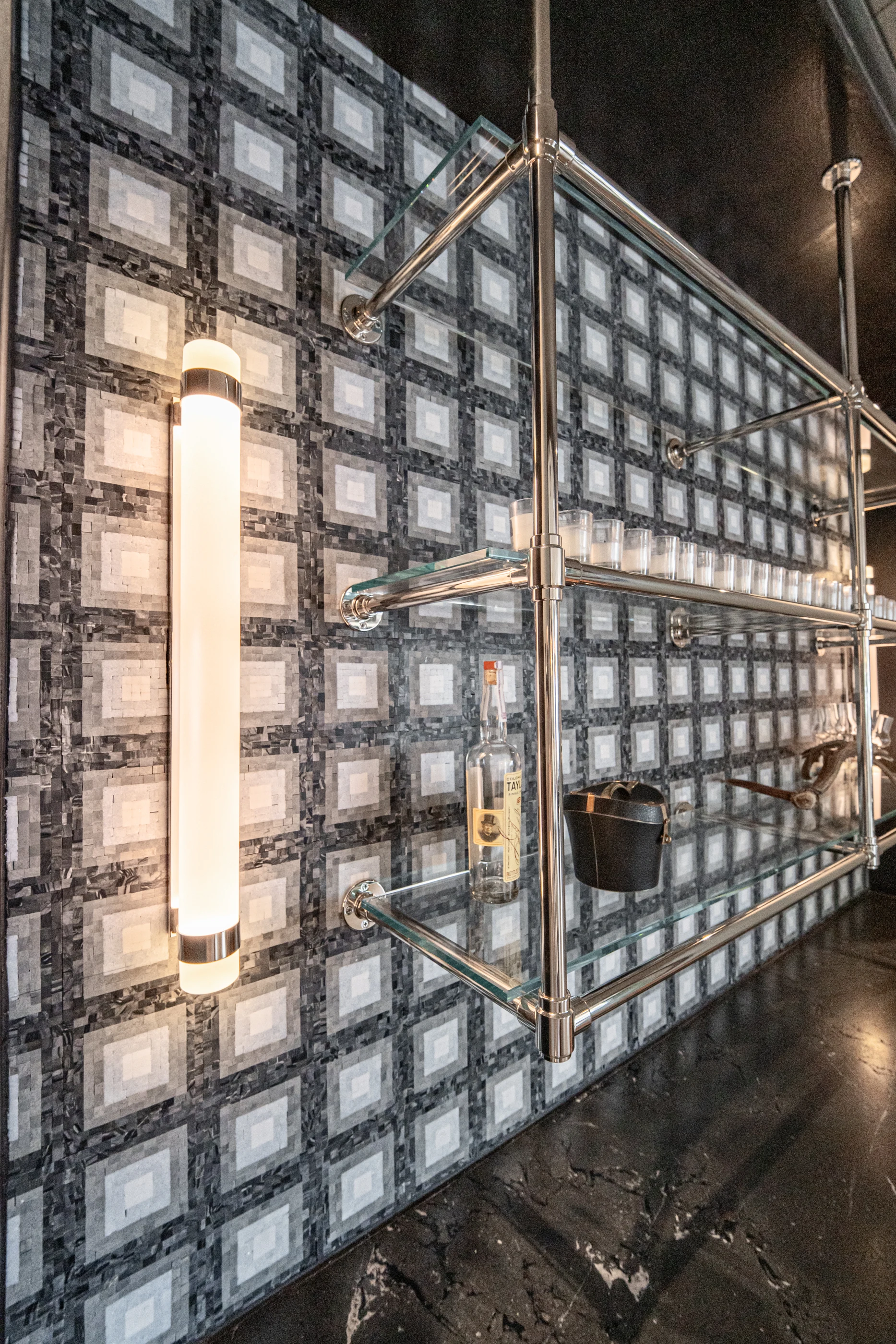 Polished rails and lighting against patterned stone in the Cabinet & Stone Lab showroom.