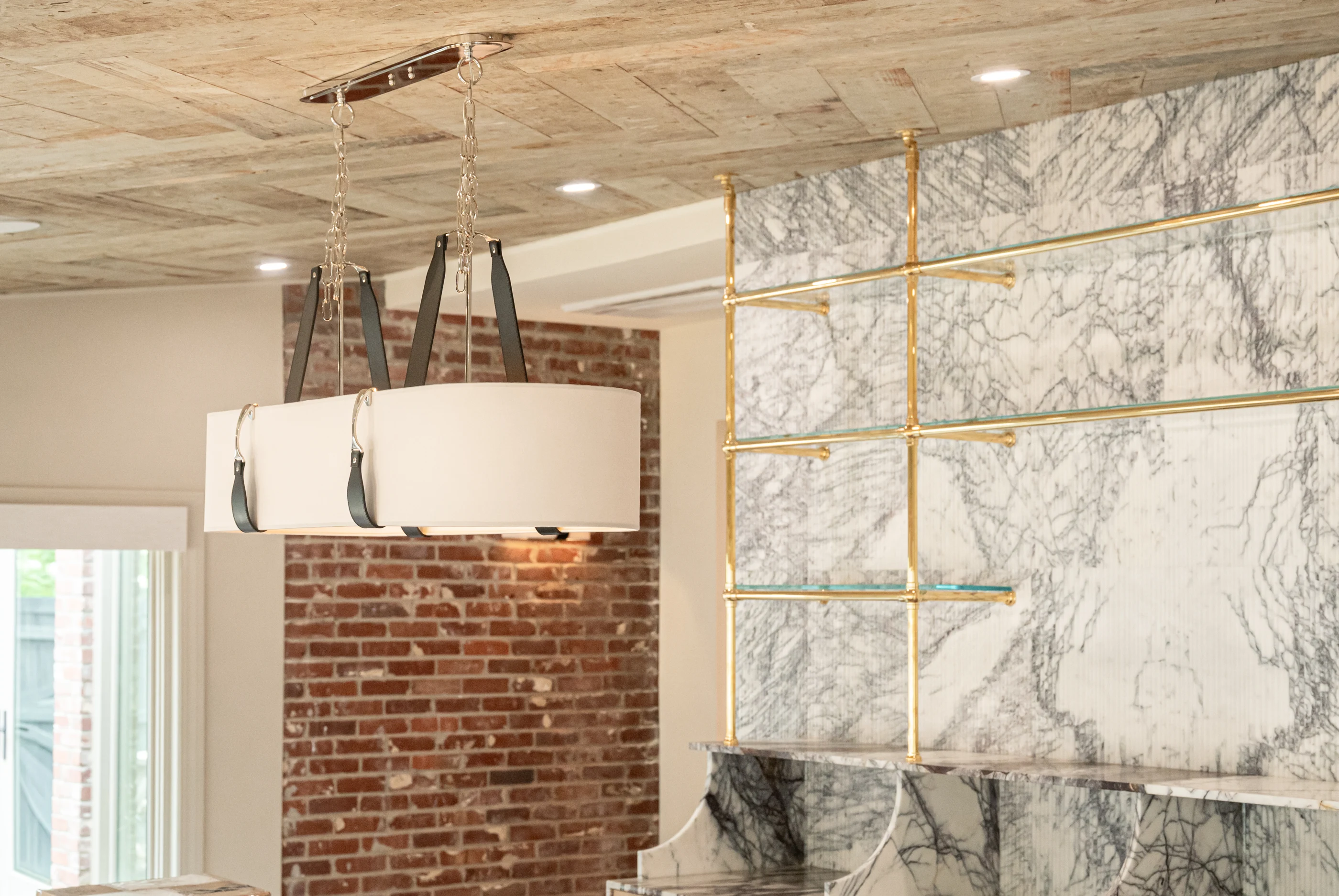 Leather-strapped pendant against brick and stone at Hart Townhouse.