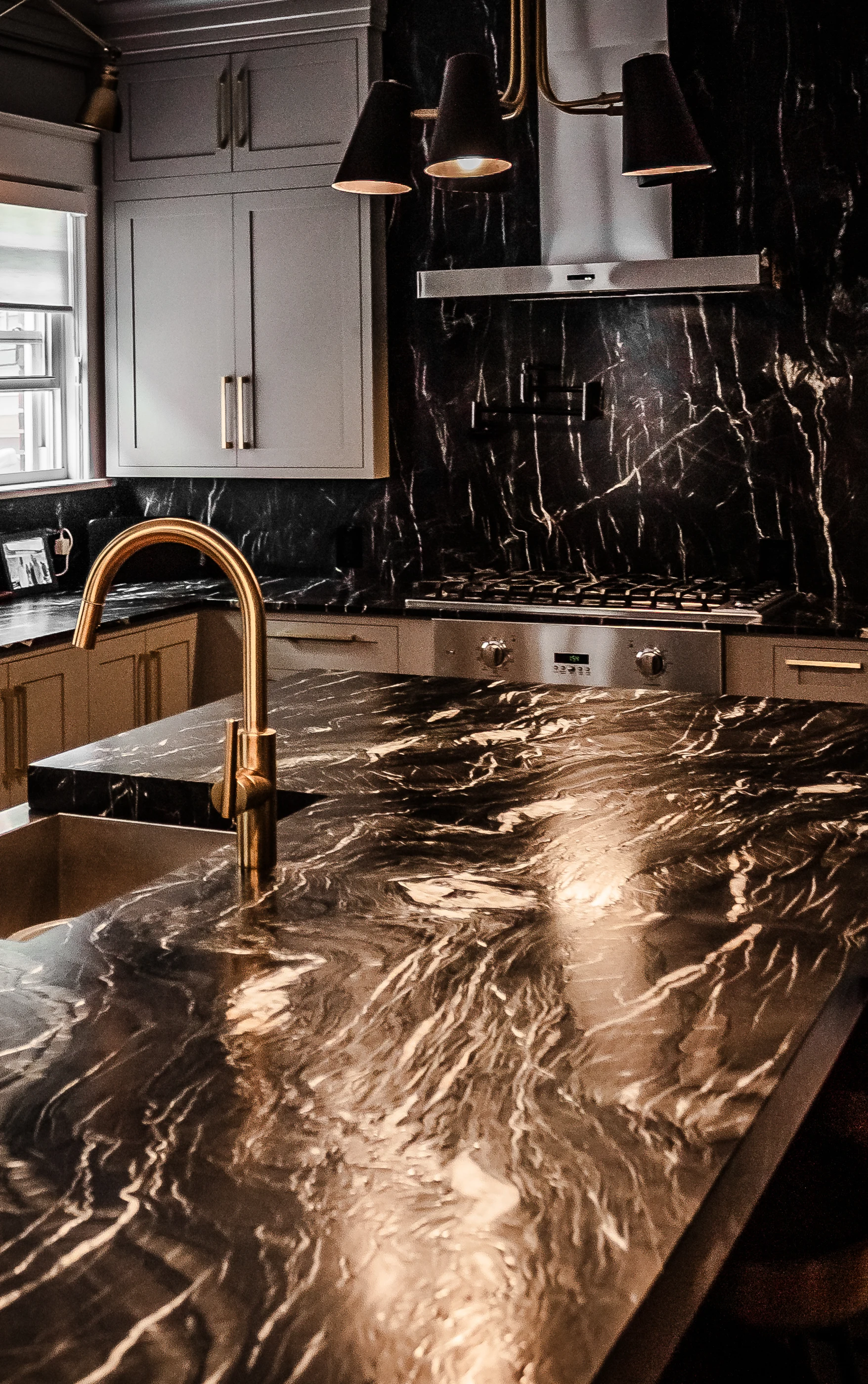 Brass faucet and richly veined kitchen countertop at Chevy Chase.