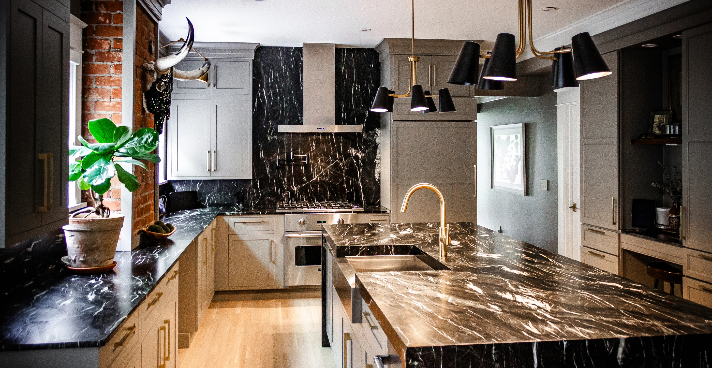Layered cabinetry, dark stone counters and brass fittings at Chevy Chase.
