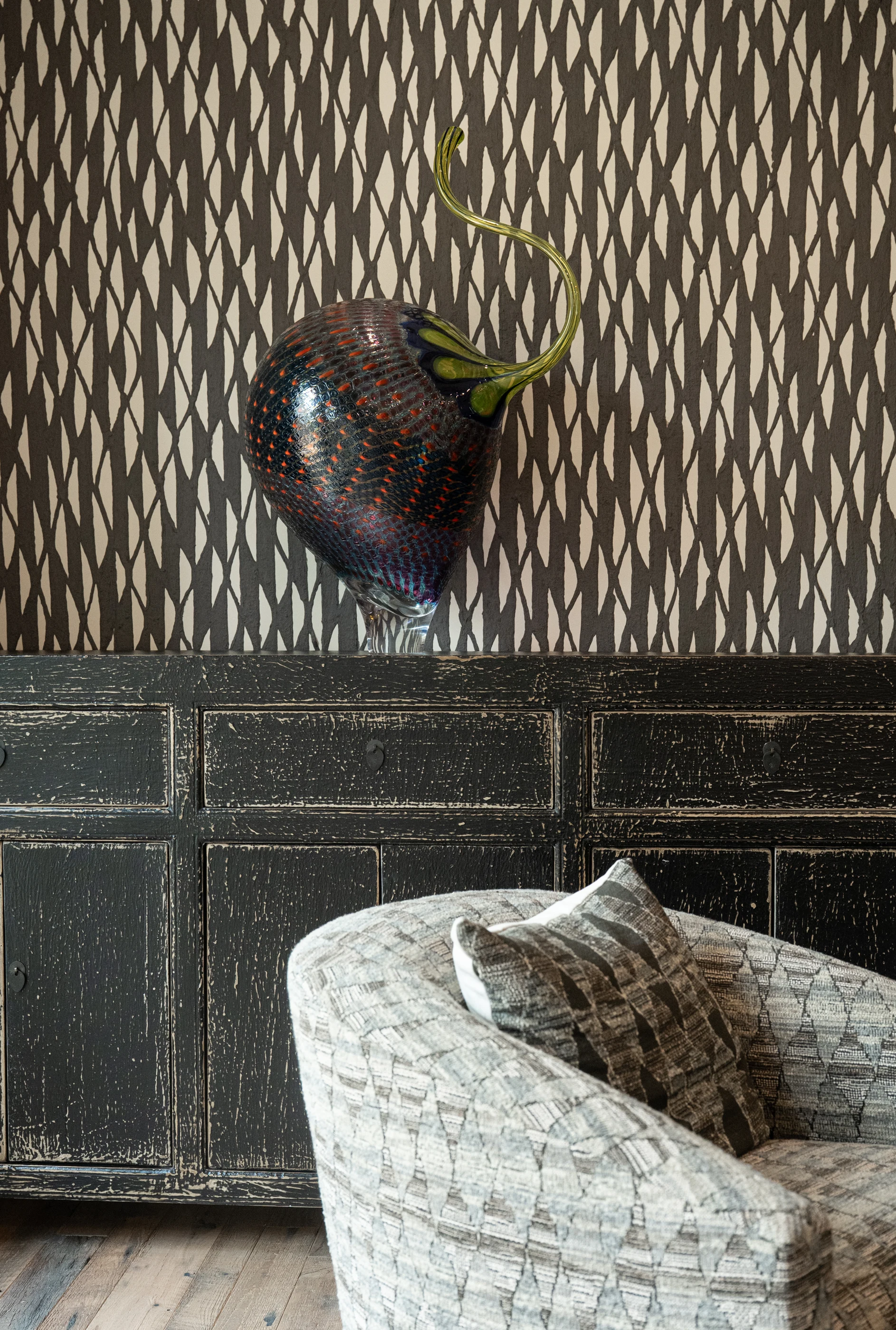 Decorative wall mask above patterned seating at Hart Townhouse.