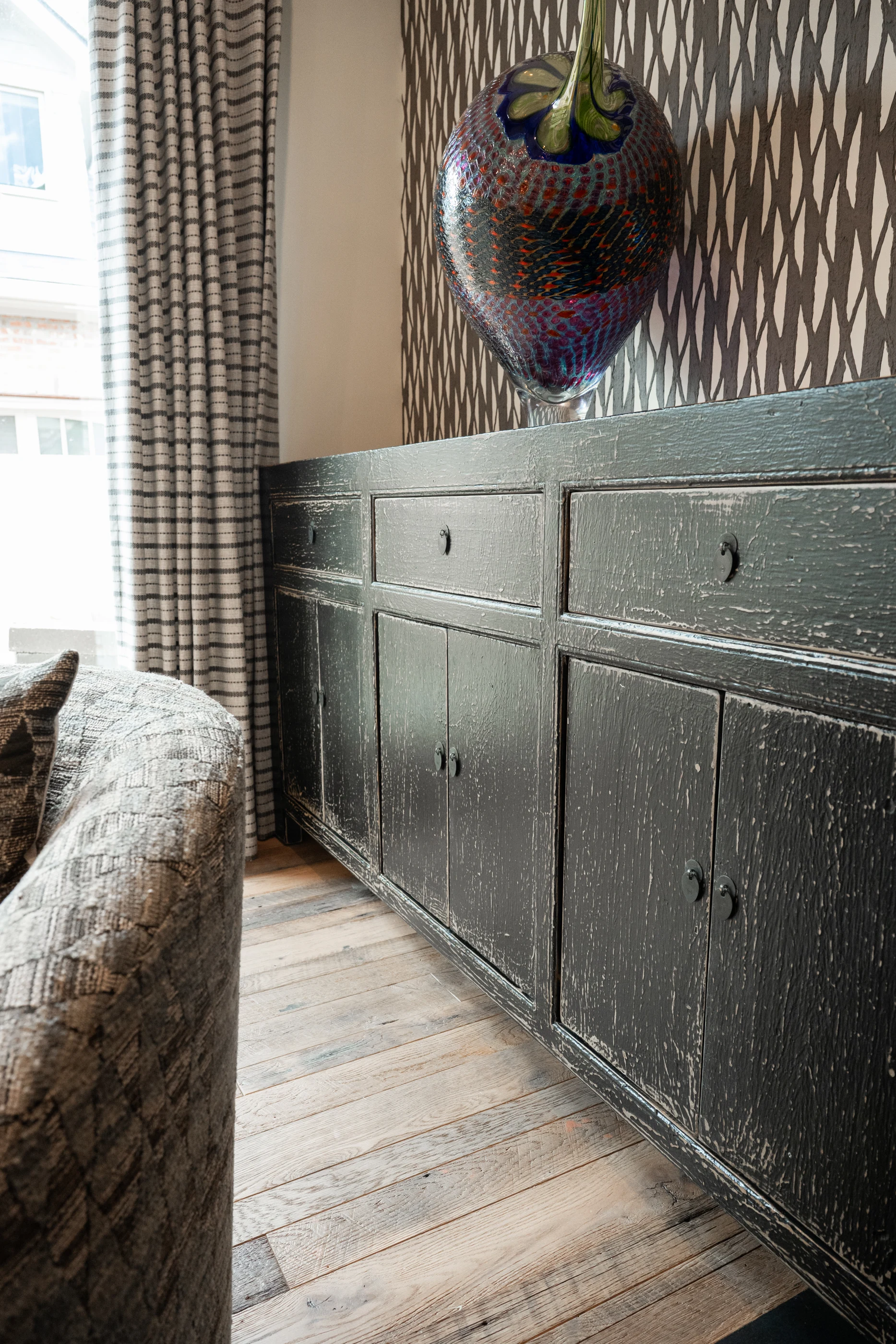 Sculptural wall mask and dark cabinetry at Hart Townhouse.