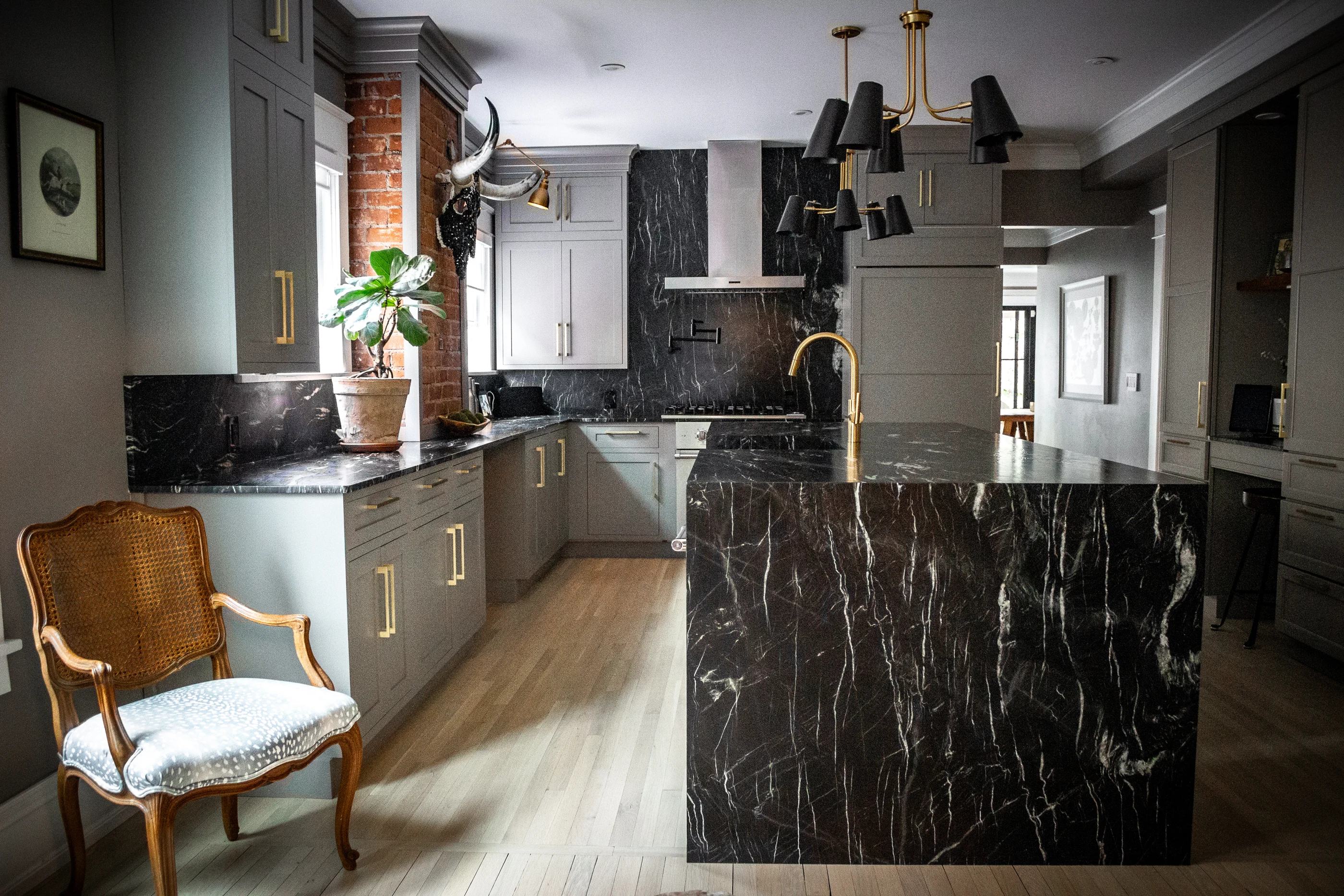 Kitchen with an antique chair and dramatic waterfall island at Chevy Chase.