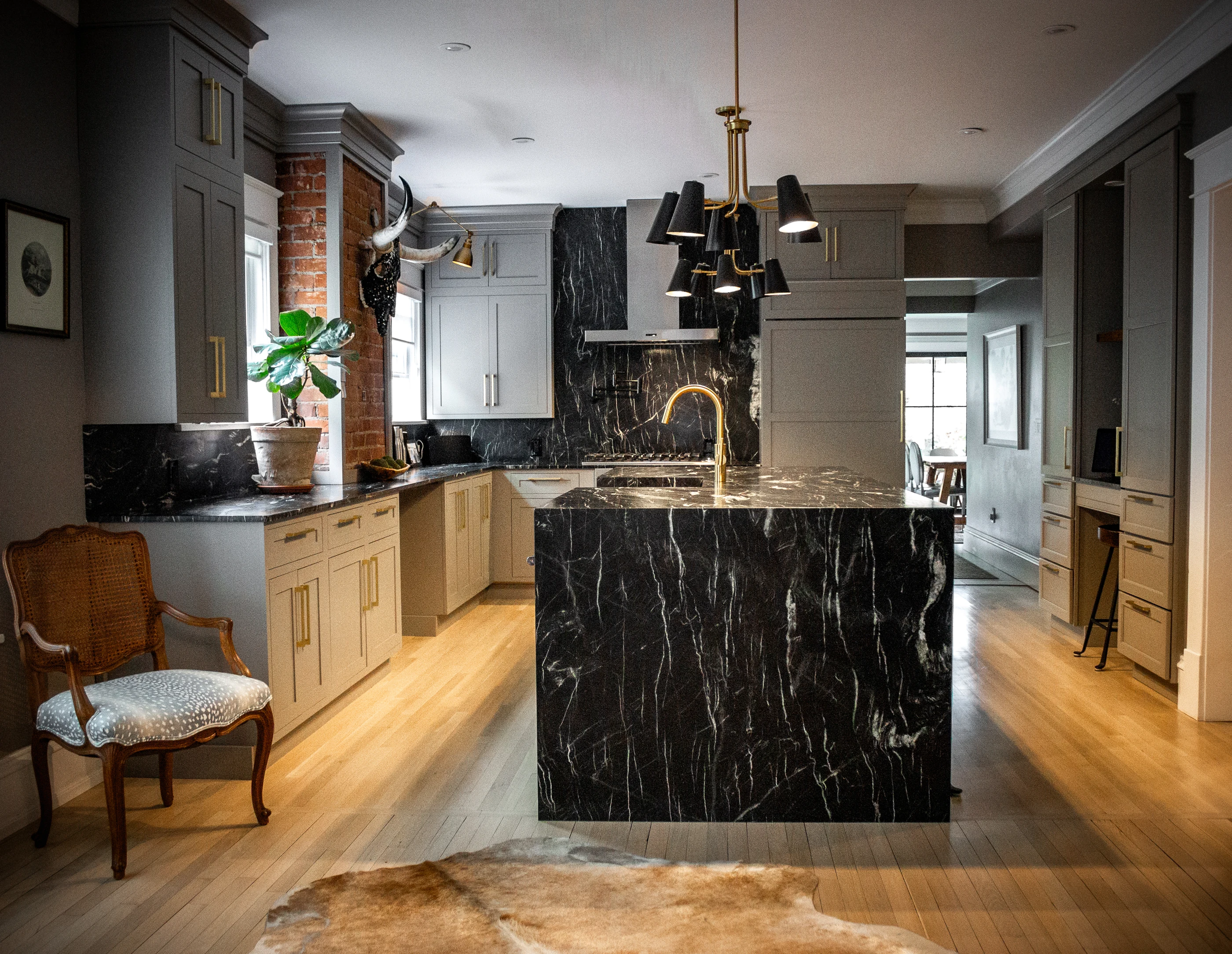 Kitchen with a dramatic dark stone island and sculptural lighting at Chevy Chase.