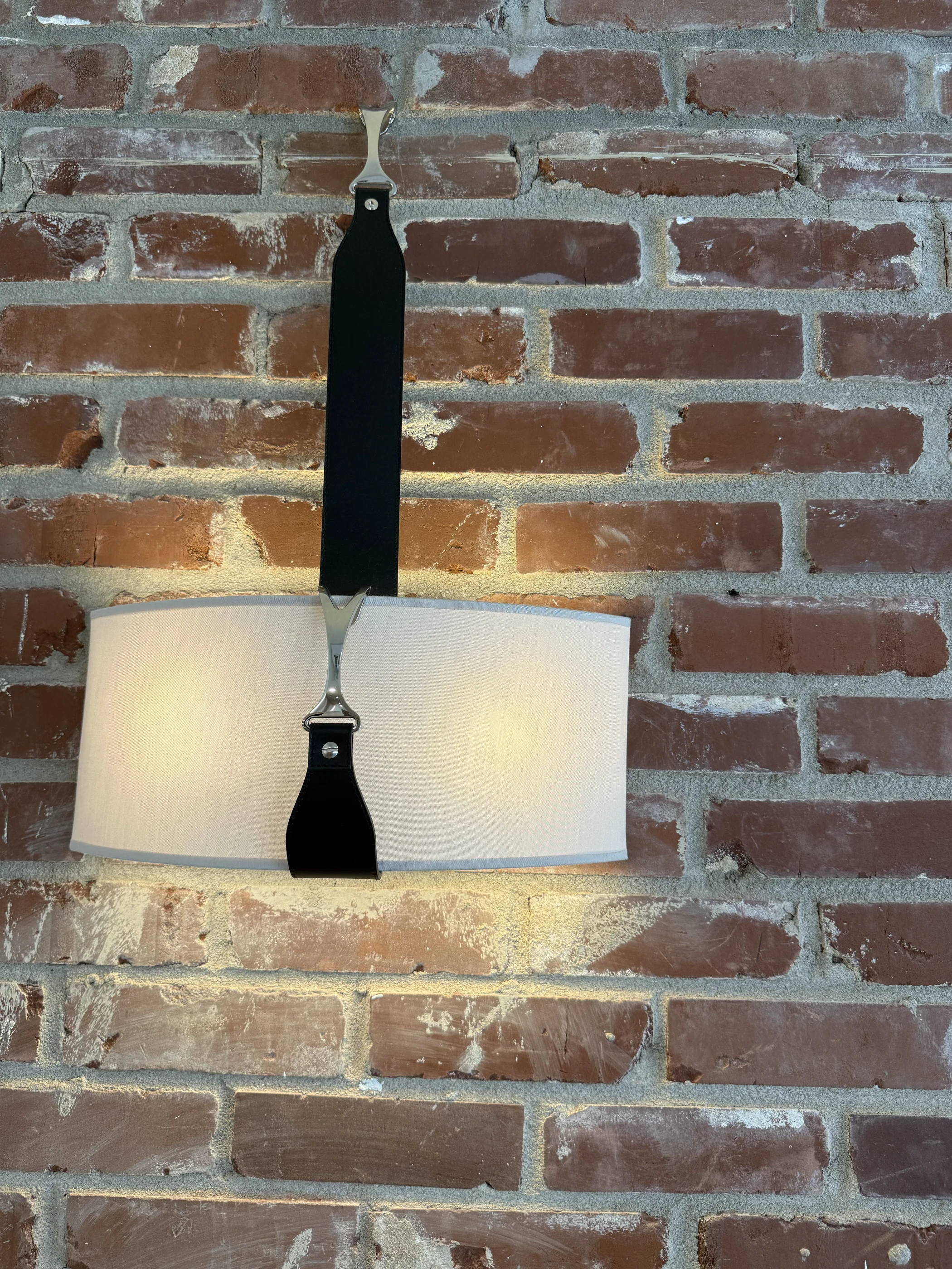 Leather-strapped lighting against brick at Hart Townhouse.