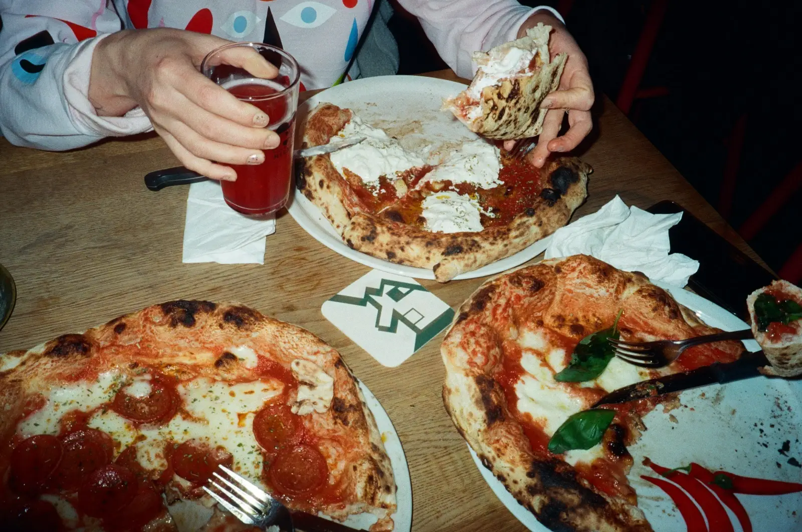 A person eating pizza by the slice