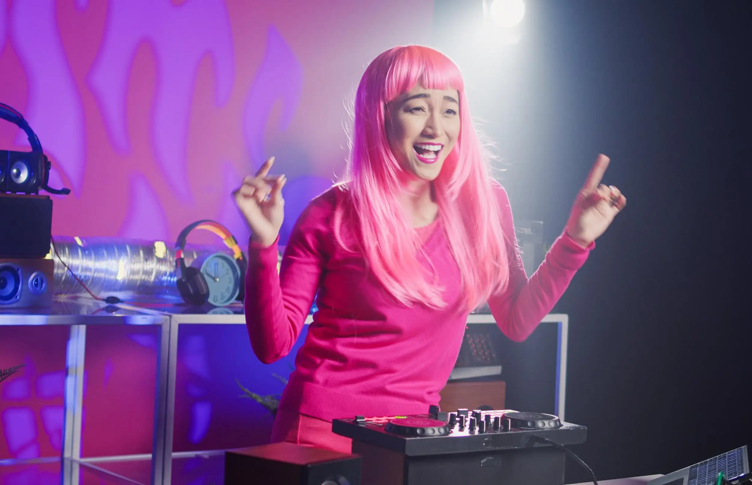 DJ with pink hair mixing live music for a Stagevoo open floor night
