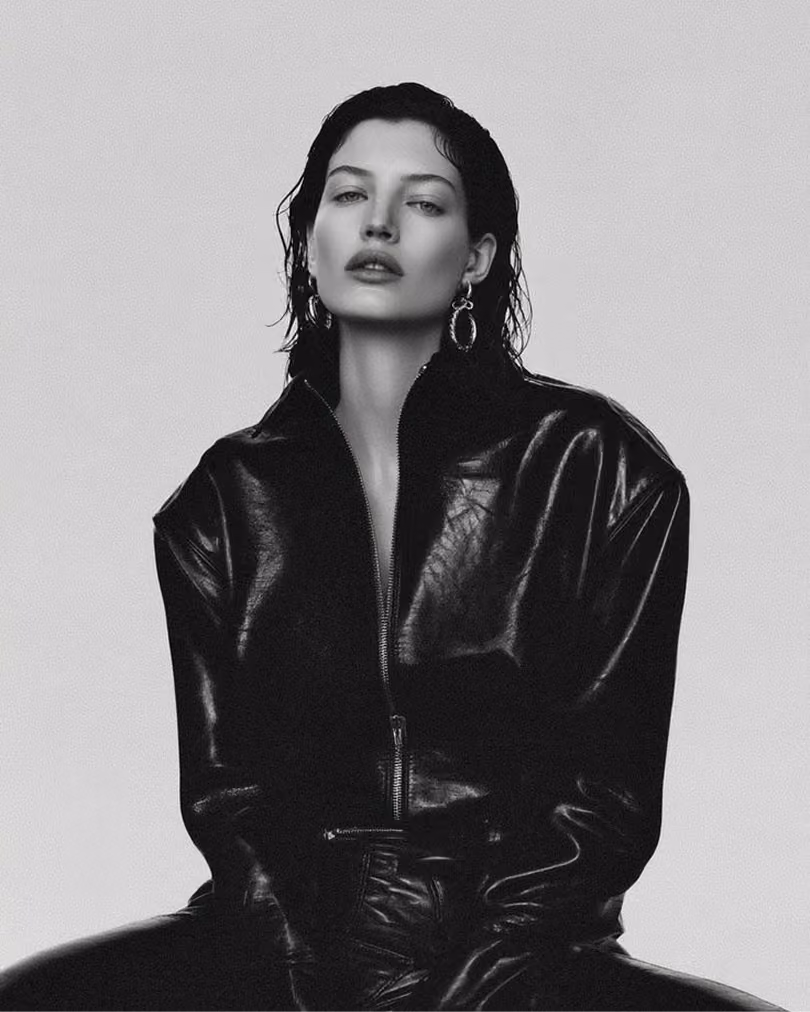 Black and white portrait of a woman in an oversized black leather jacket