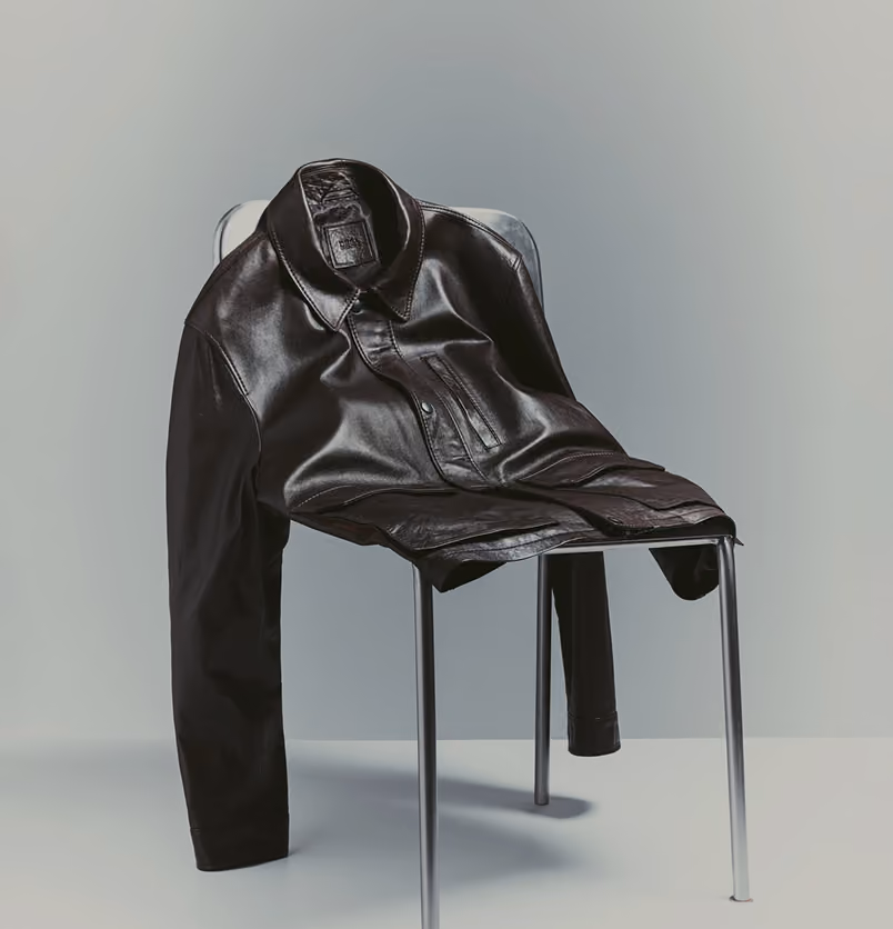 Dark leather jacket draped over a metal chair