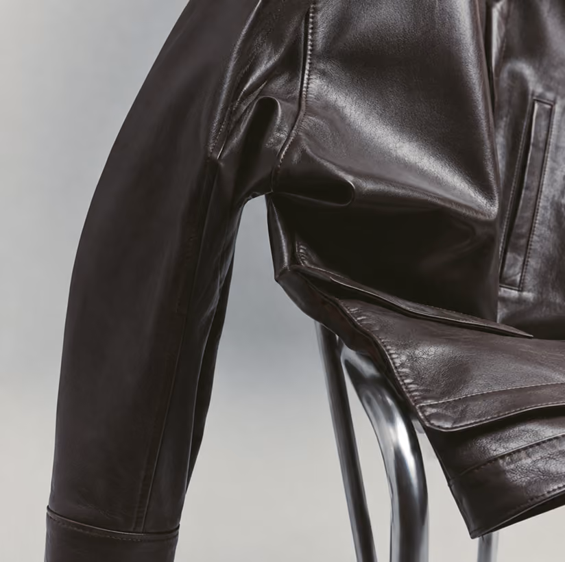 Dark leather jacket sleeve and shoulder resting on a metal chair