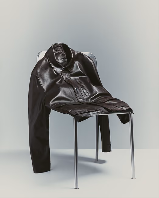 Dark leather jacket draped over a metal chair
