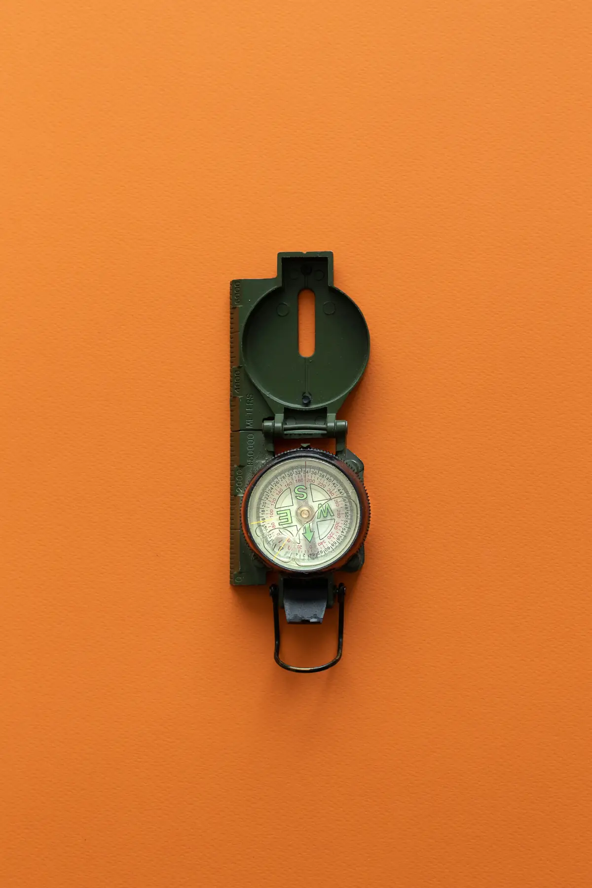 An open field compass on a flat orange ground