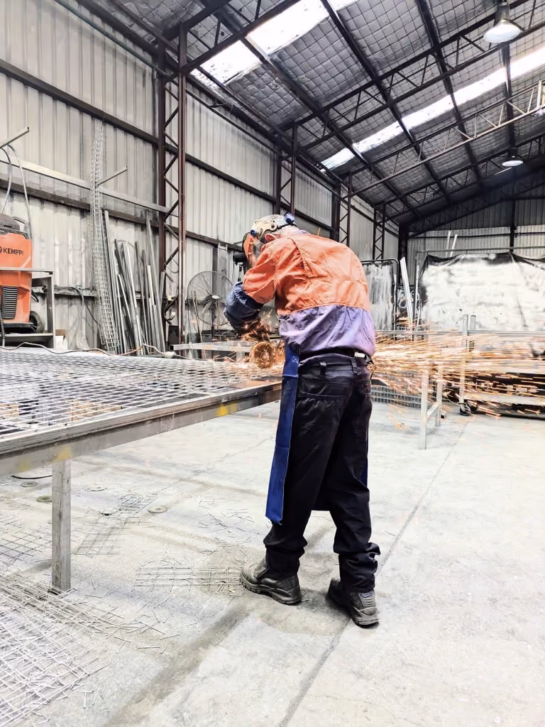 An Autolift employee welding in a warehouse