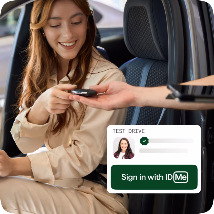 Smiling woman in a beige outfit sits in the driver's seat of a car, reaching to take a car key from a person's outstretched hand outside the vehicle, with a graphic overlay showing a test drive sign-in prompt featuring a user's photo and a green button labeled 'Sign in with IDMe'.