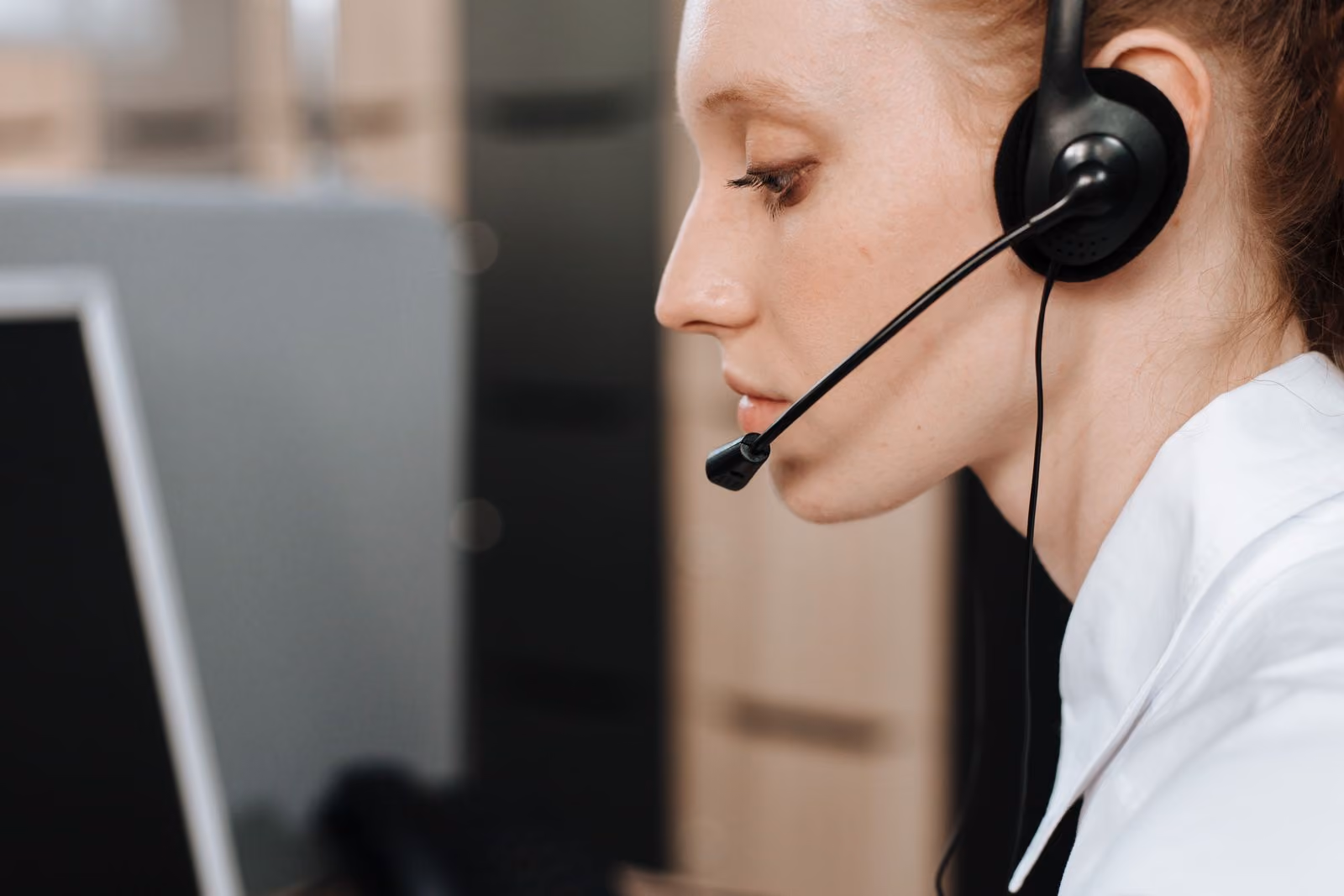 Eine Person mit Headset am Computer beantwortet eine Kundenfrage