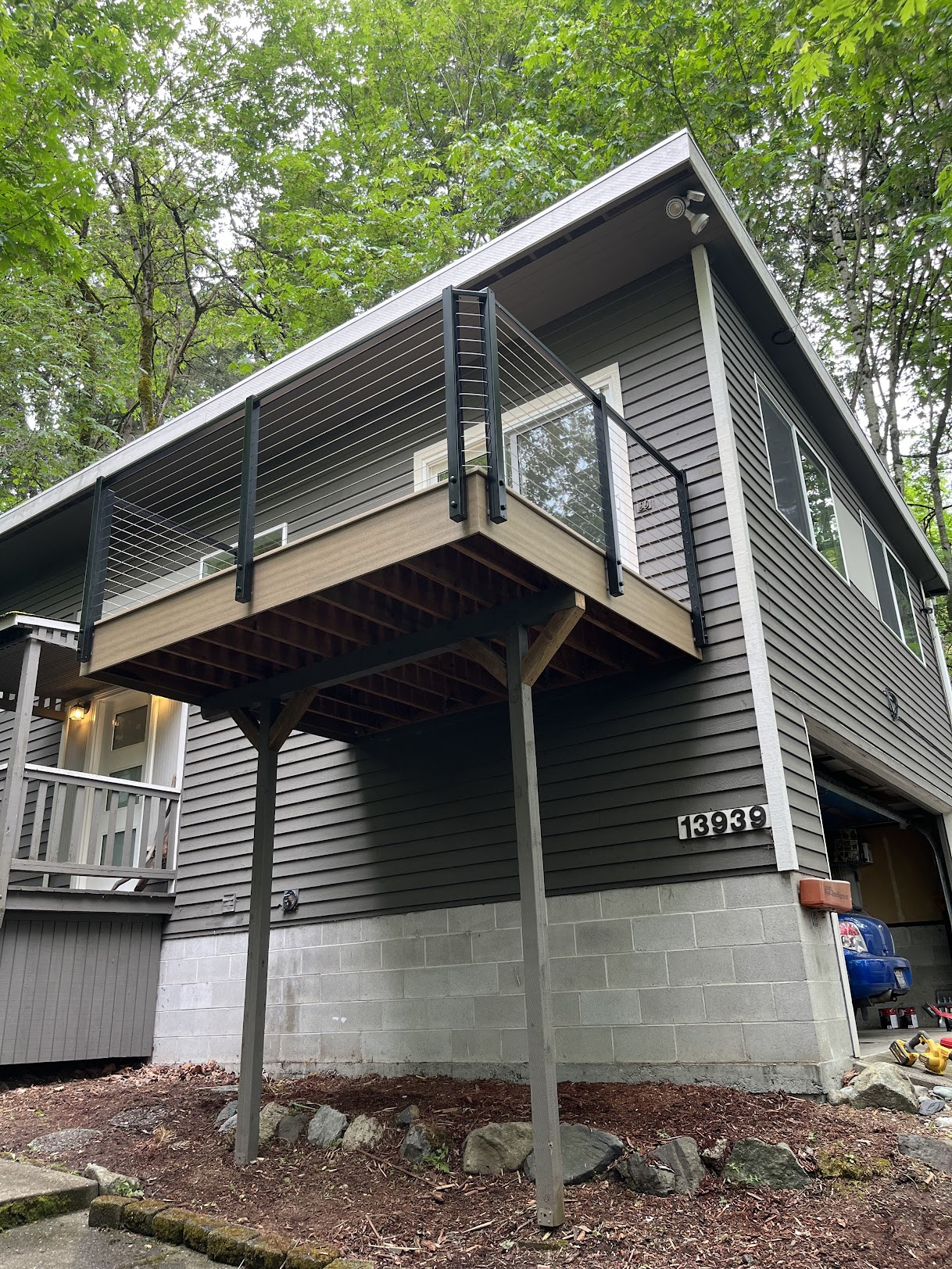 Fully restored elevated deck featuring composite boards and modern black cable railings.