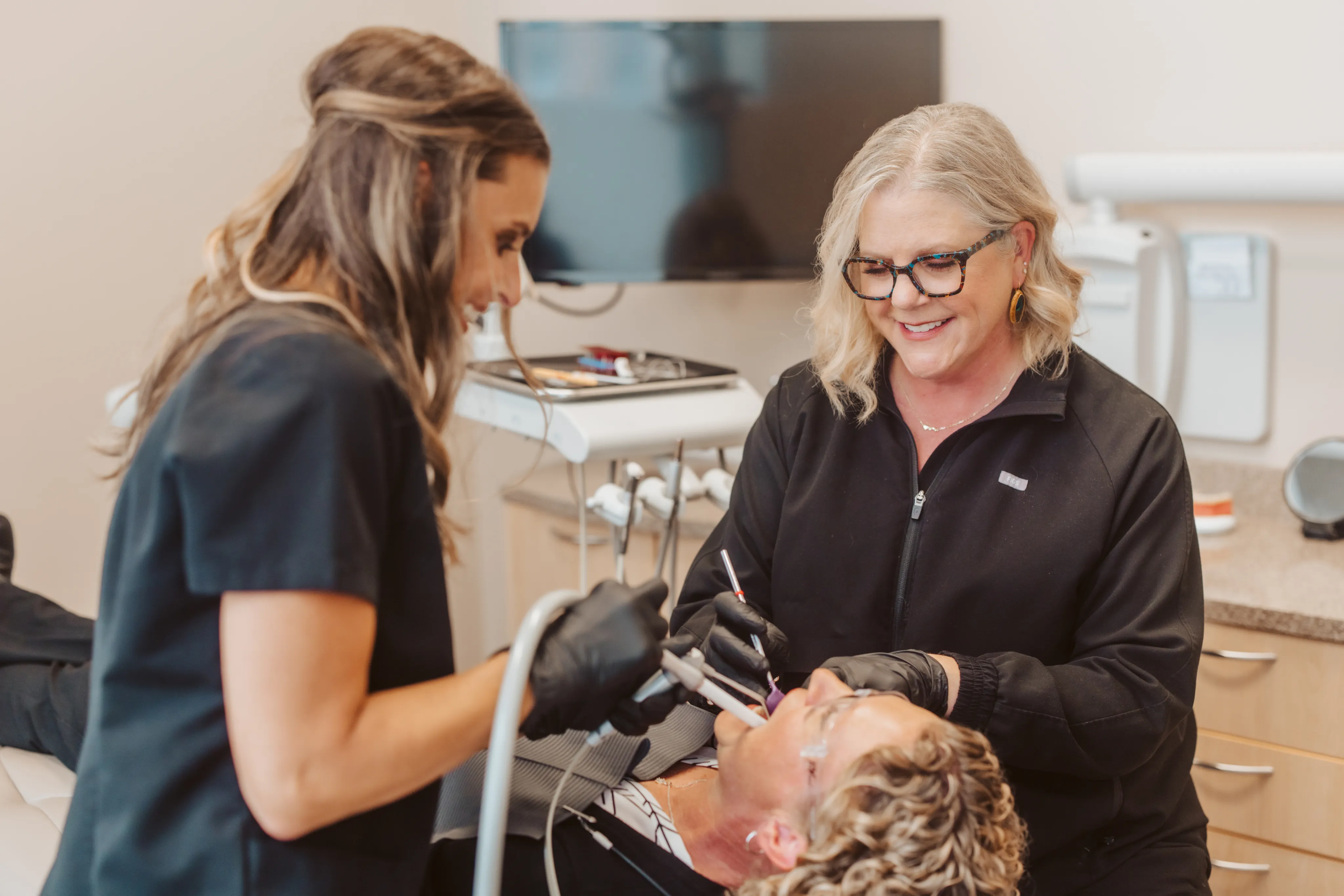 Two clinicians with a reclined patient during Invisalign treatment