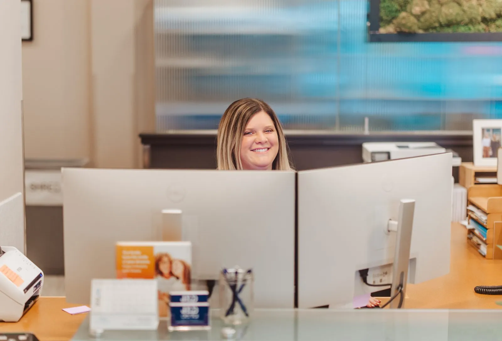 J & D Dental front desk team member smiling behind the reception counter