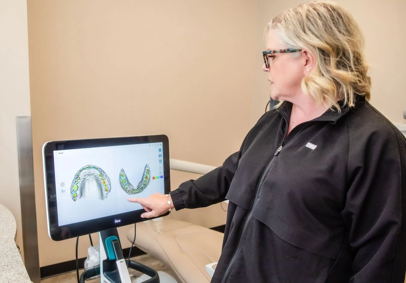 Dr. Herbert pointing at a digital treatment scan on a chairside monitor