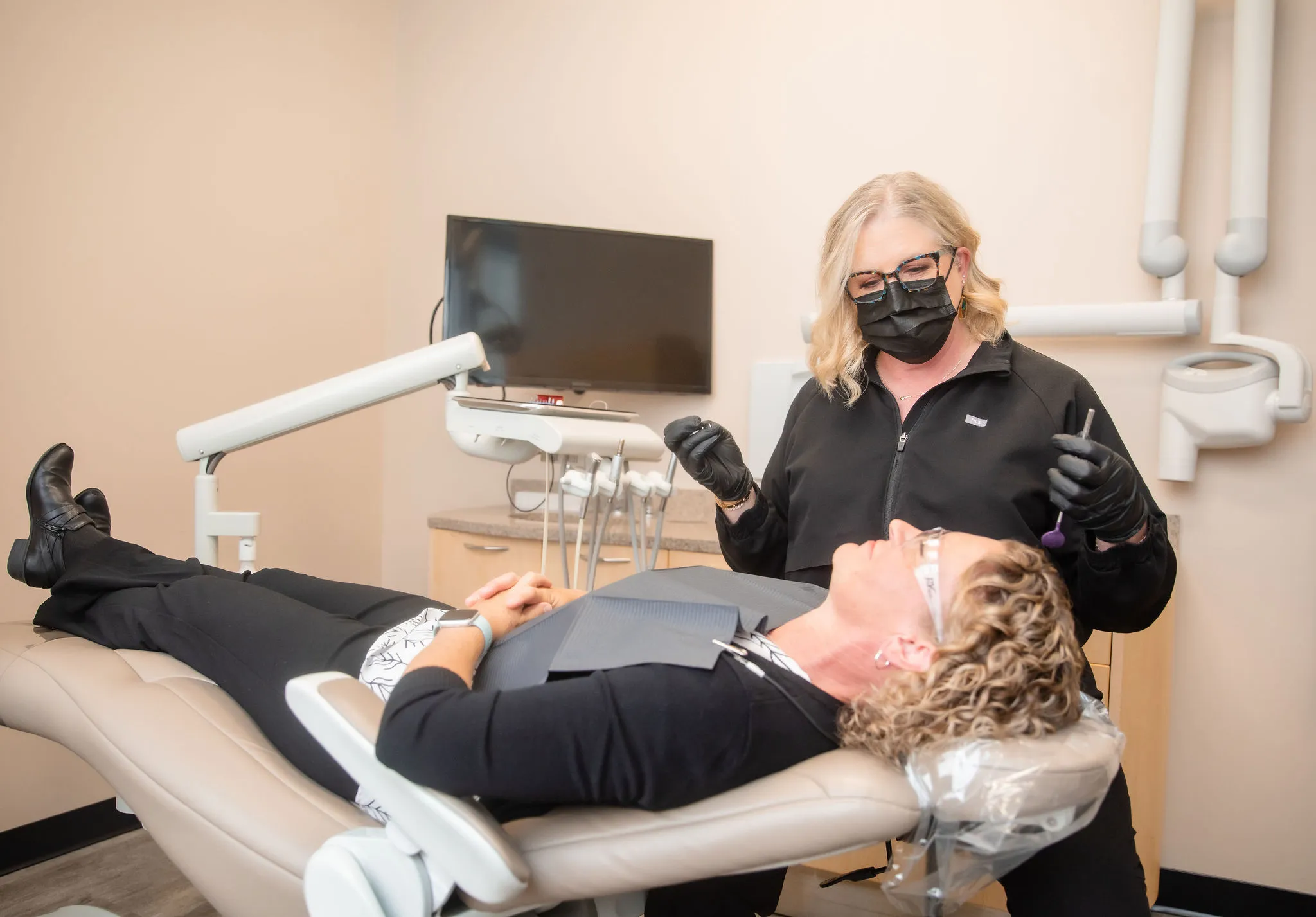 Dr. Jennifer Herbert in a mask and gloves preparing to examine a patient.
