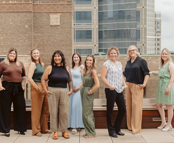 Group of women smiling on a Minneapolis rooftop