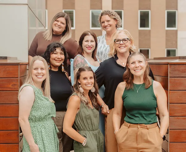Group of women smiling on a Minneapolis rooftop