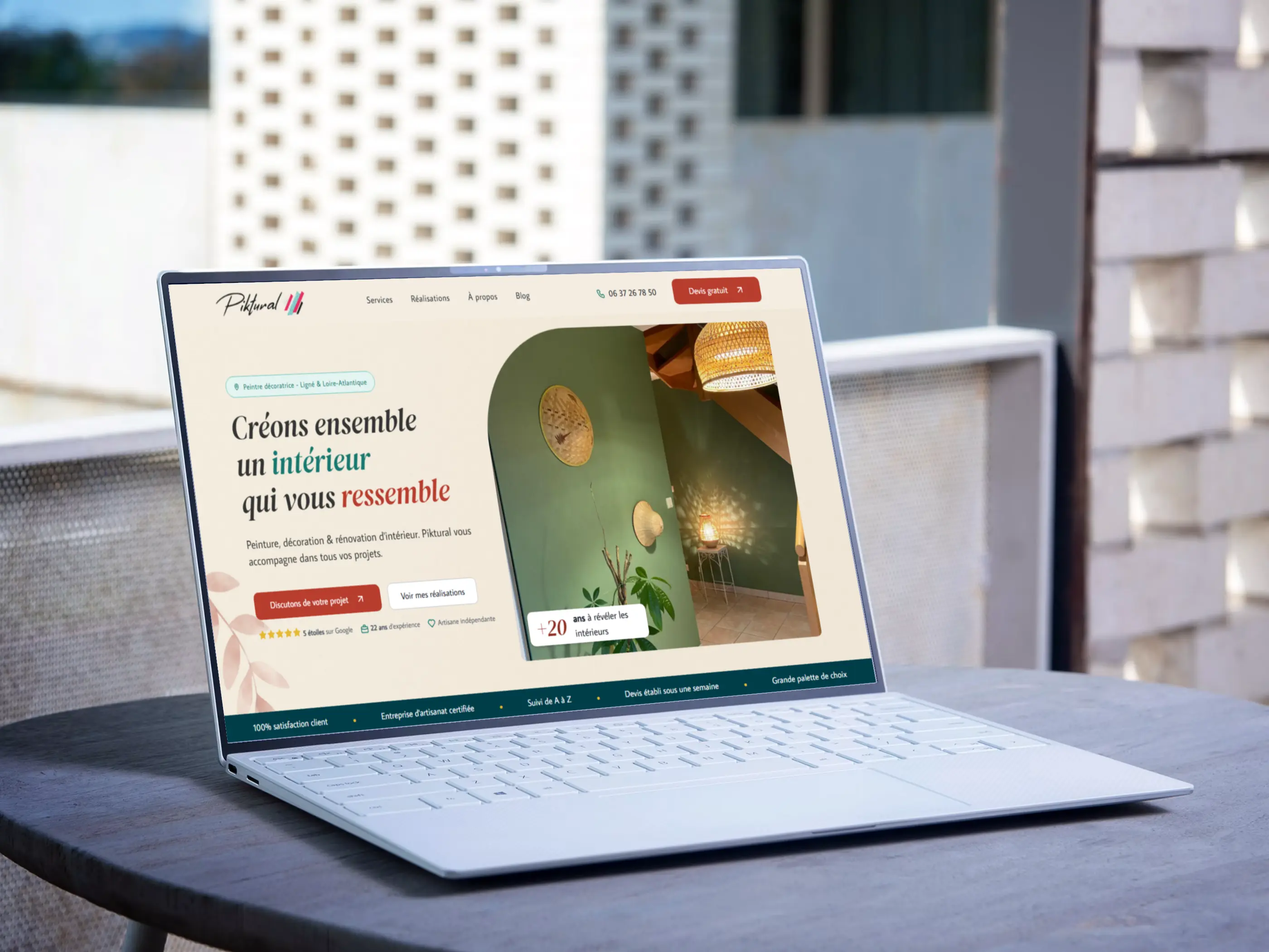 Le site de Piktural affiché sur un ordinateur portable posé sur une table en terrasse