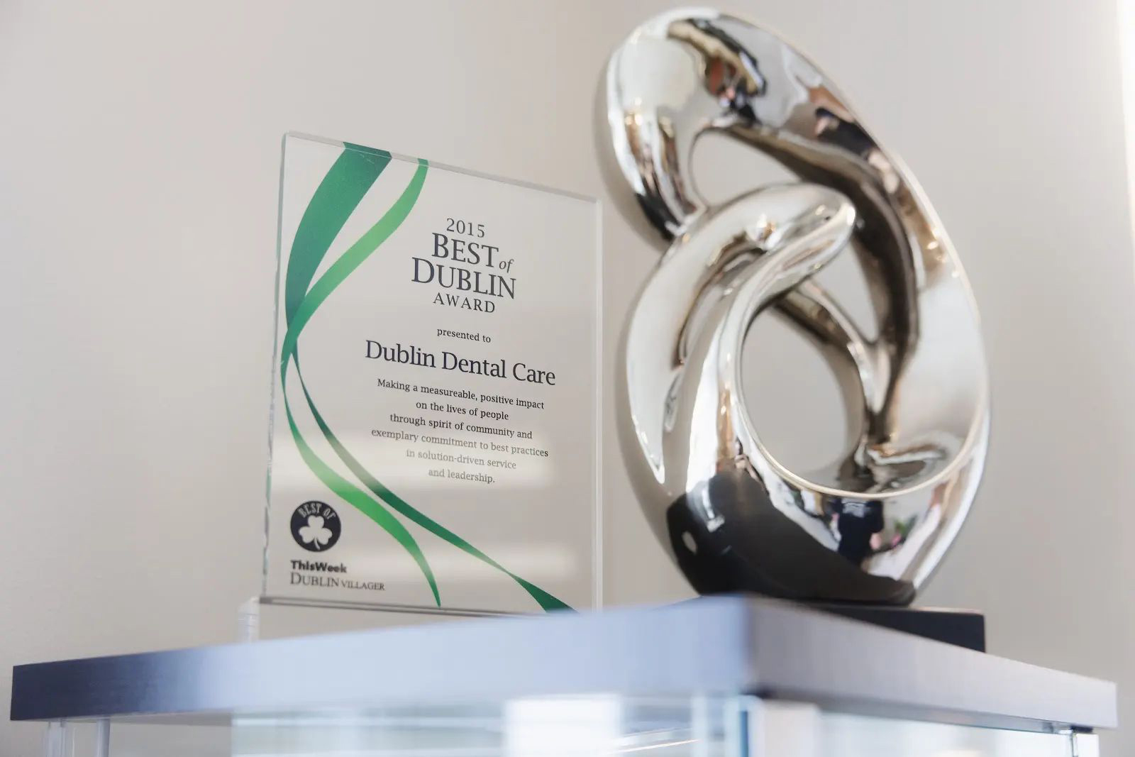2015 Best of Dublin Award presented to Dublin Dental Care, placed next to a modern silver abstract sculpture on a shelf.
