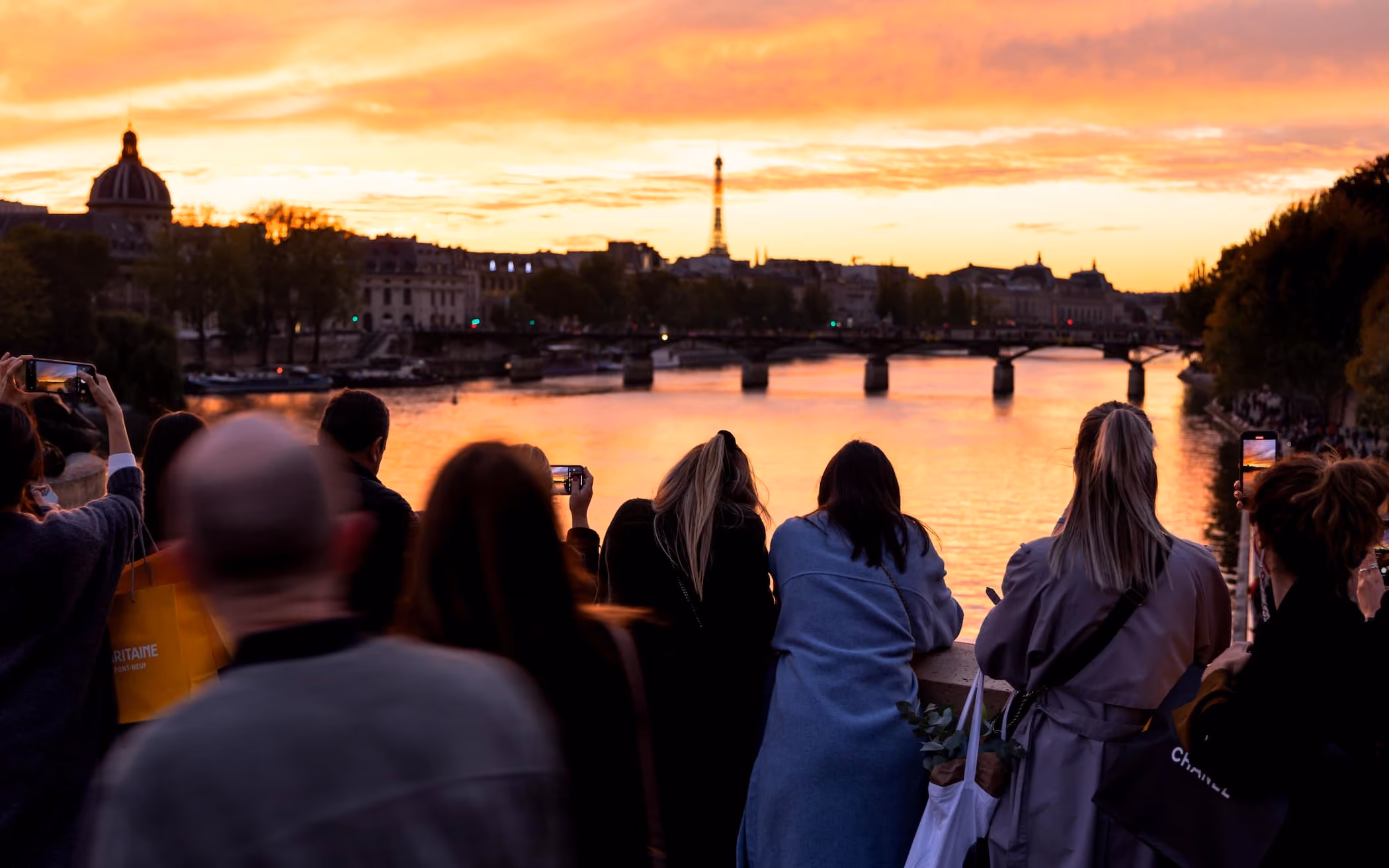 personnes regardant la tour eiffel et paris pendant un coucher de soleil