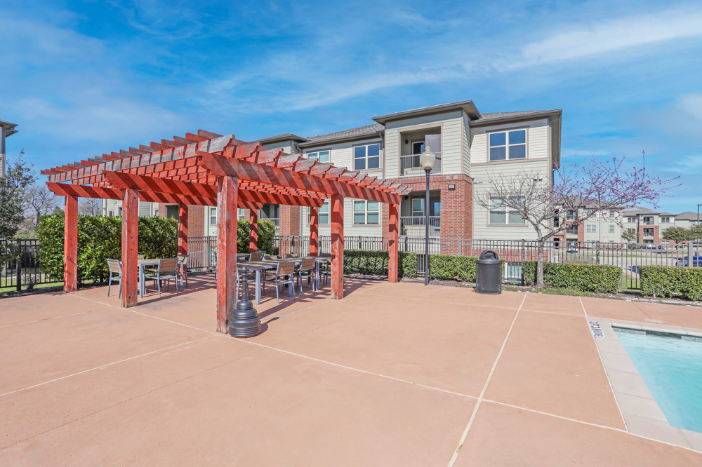 Poolside seating area with view of apartment buildings