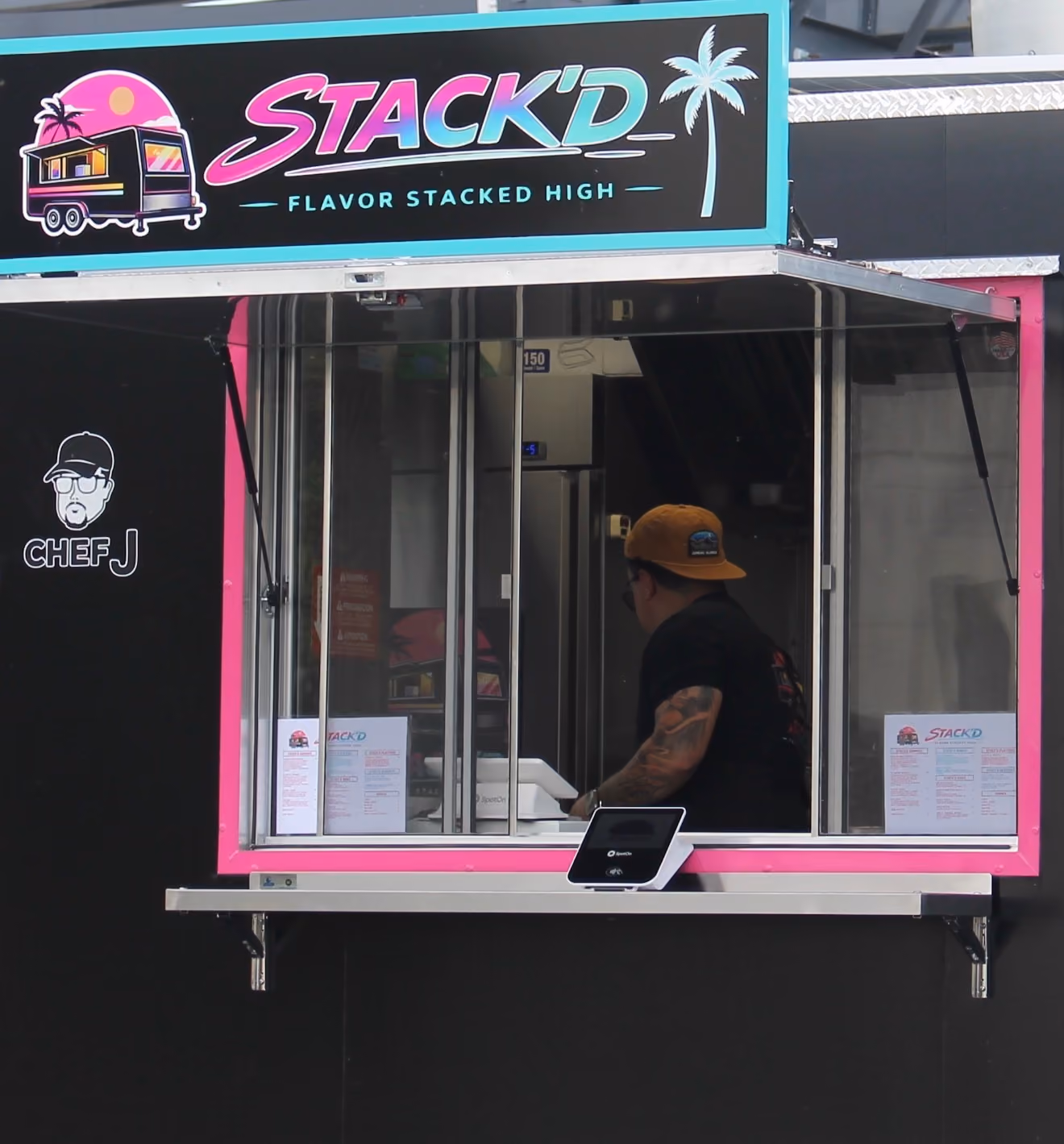 Food truck with turquoise and pink trim named STACK'D
