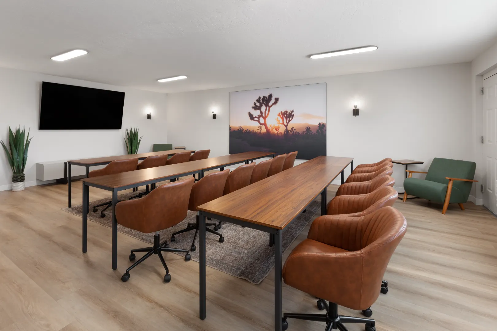 Meeting room at Kokopelli Inn Sedona set up in classroom style with rows of tables and a wall-mounted TV