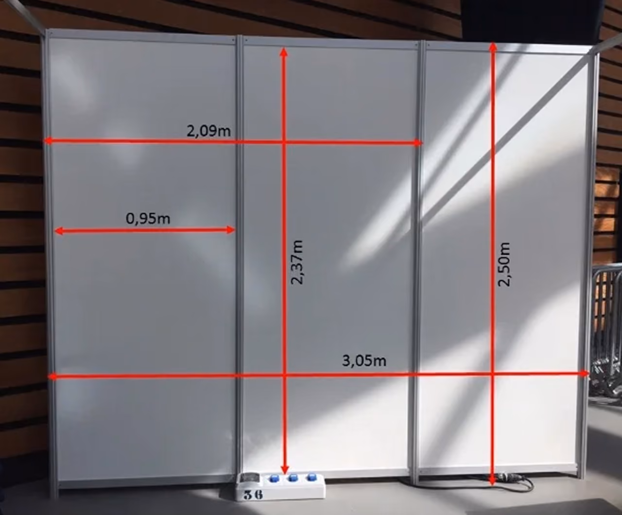 White panel walls with red measurement lines showing heights and widths in meters.