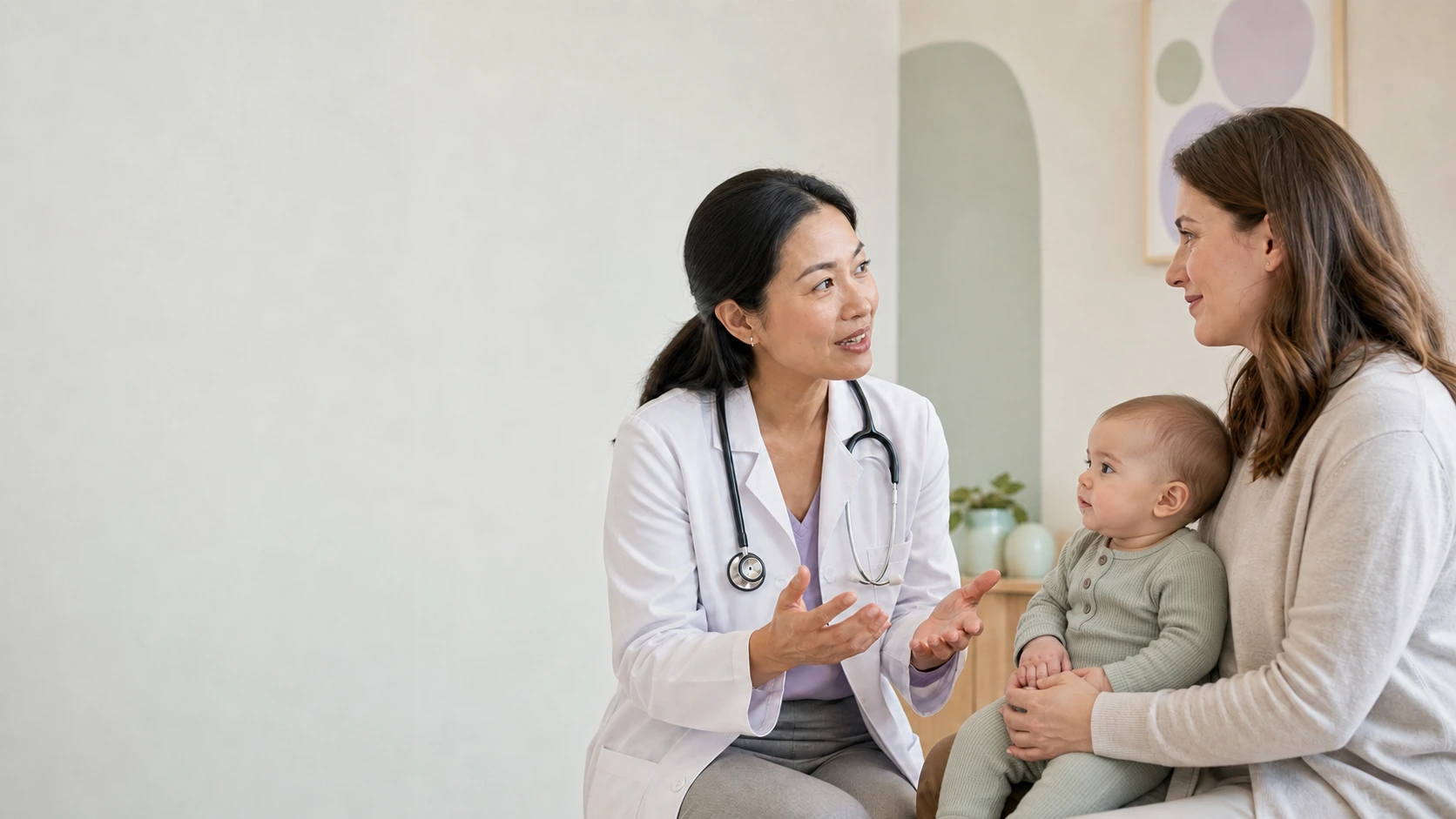 Pediatrician speaking with a mother holding her baby