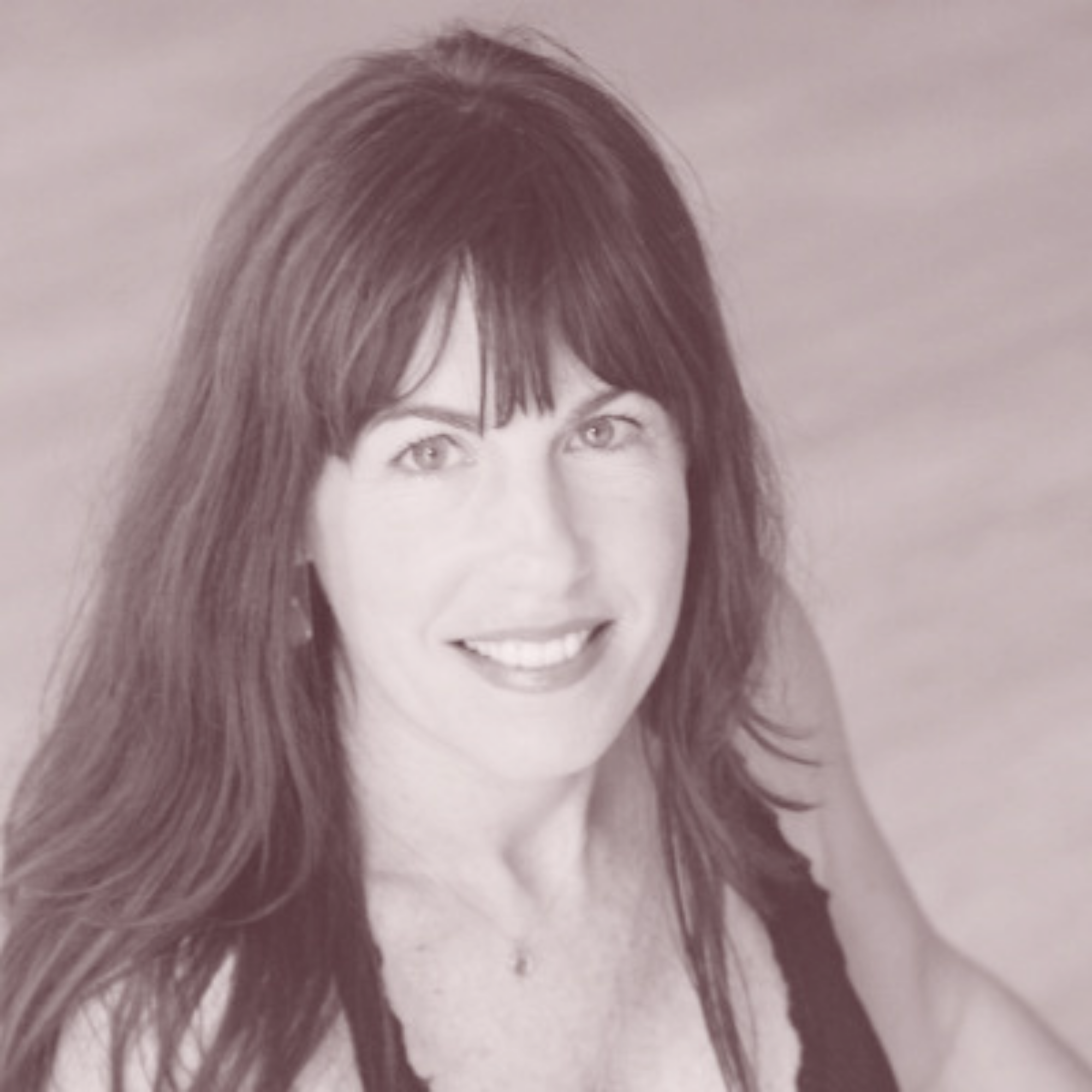 Headshot of a woman with long dark hair and bangs, smiling and looking at the camera, wearing a sleeveless top.