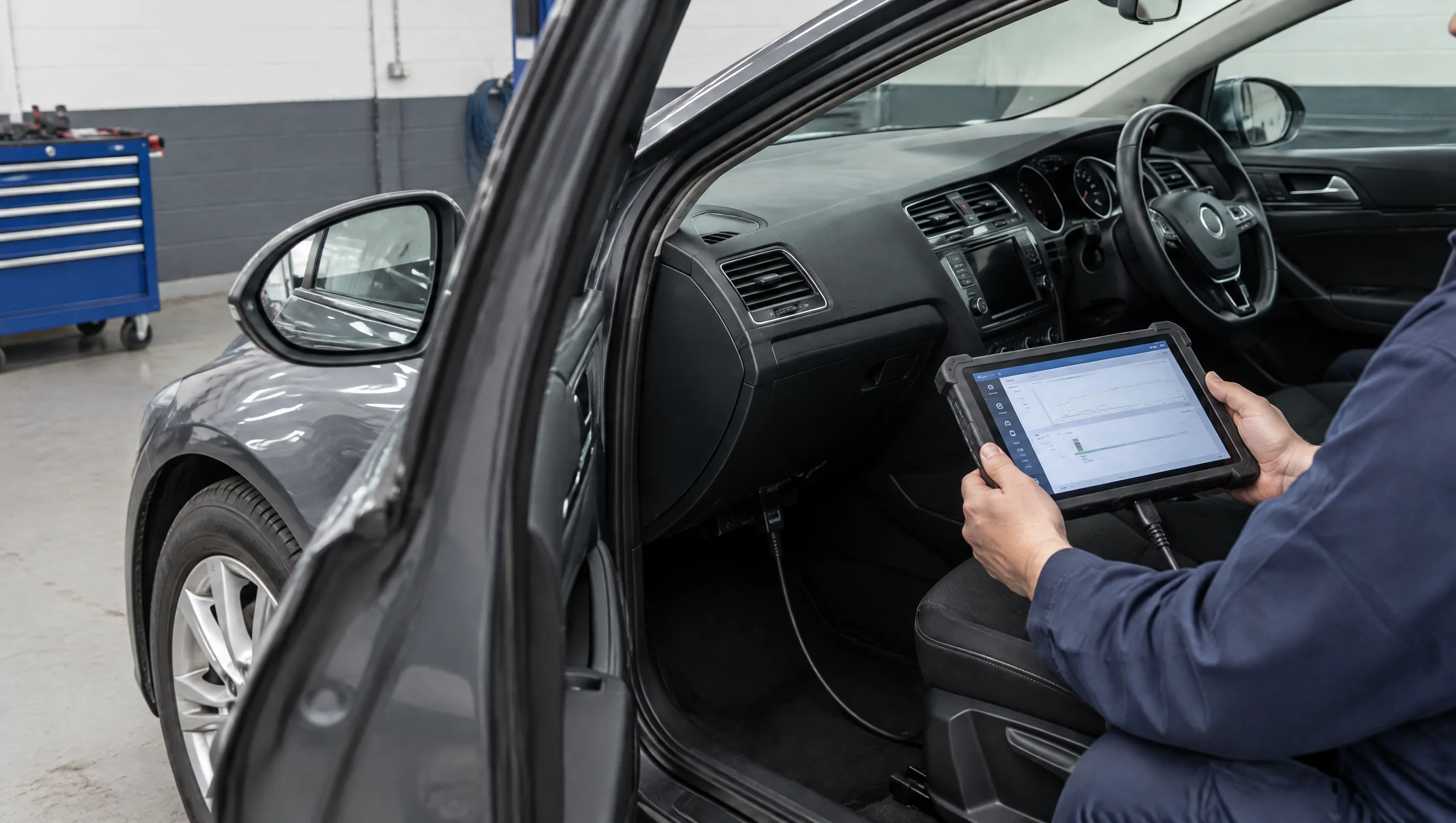 Illustrative image of a diagnostic tablet connected to a right-hand-drive car.