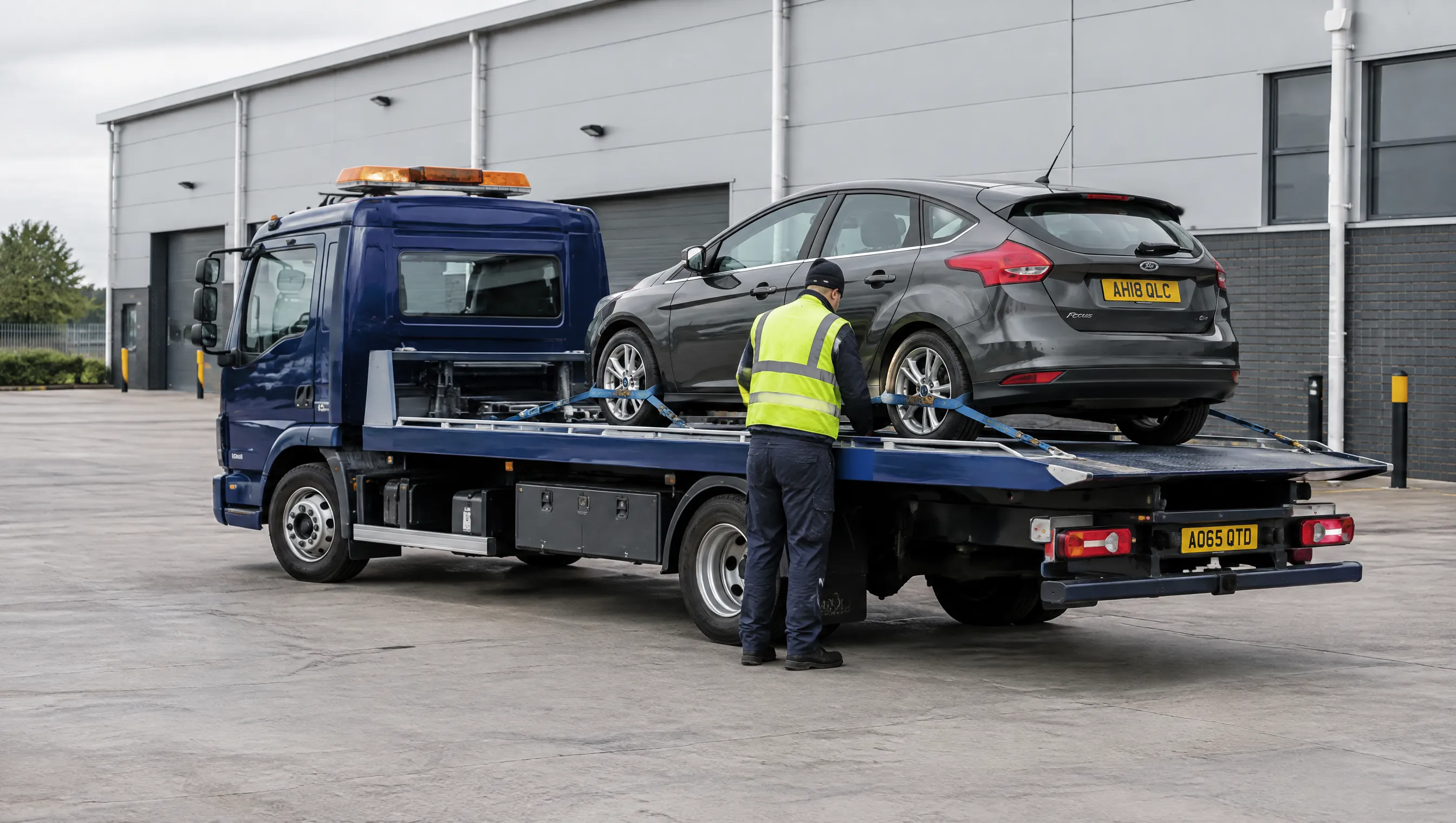 Illustrative image of a car secured to an unbranded recovery flatbed.
