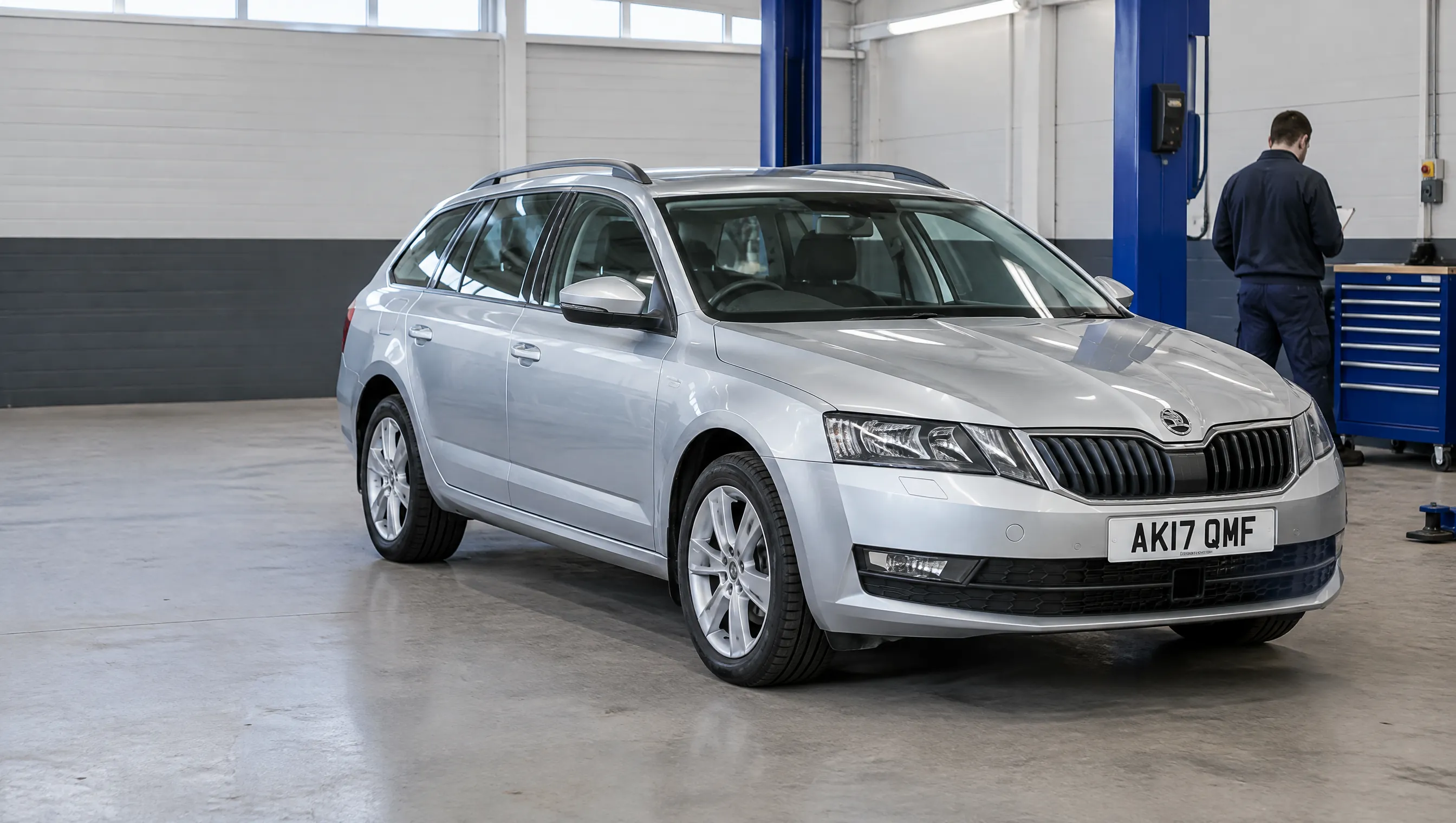 Illustrative image of a family estate car beside a garage inspection bay.
