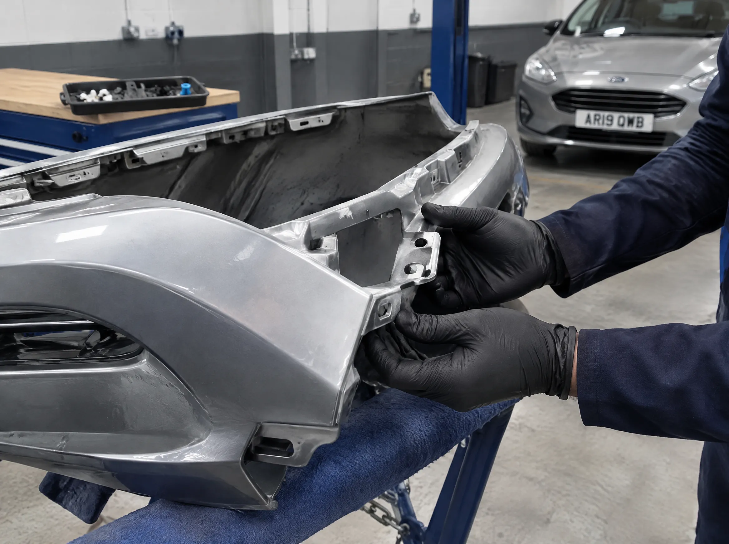Illustrative image of a bumper mounting point being assessed in a body repair area.