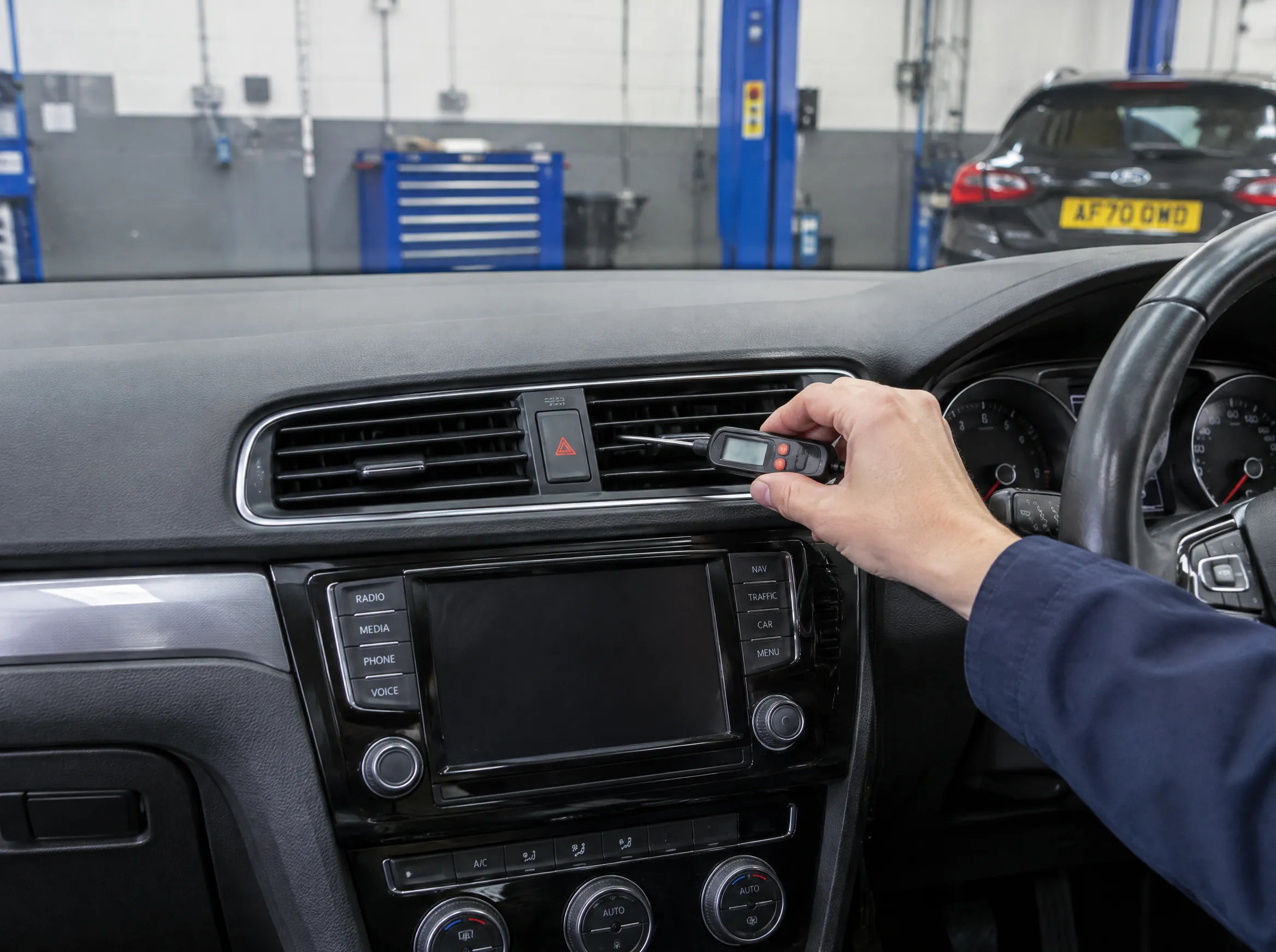Illustrative image of an air conditioning performance check at a car vent.