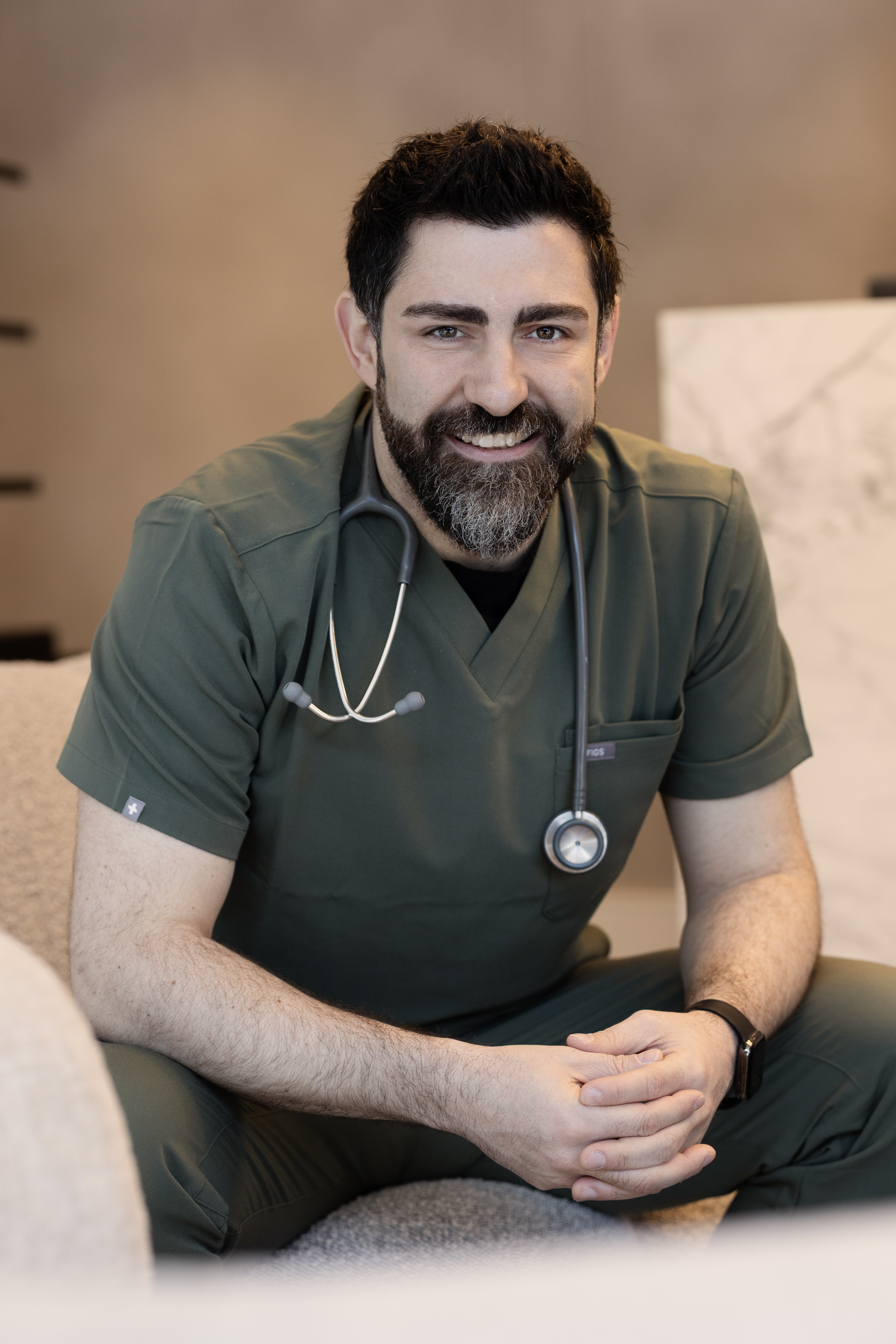 Dr Cemal Kavasogullari seated in medical scrubs