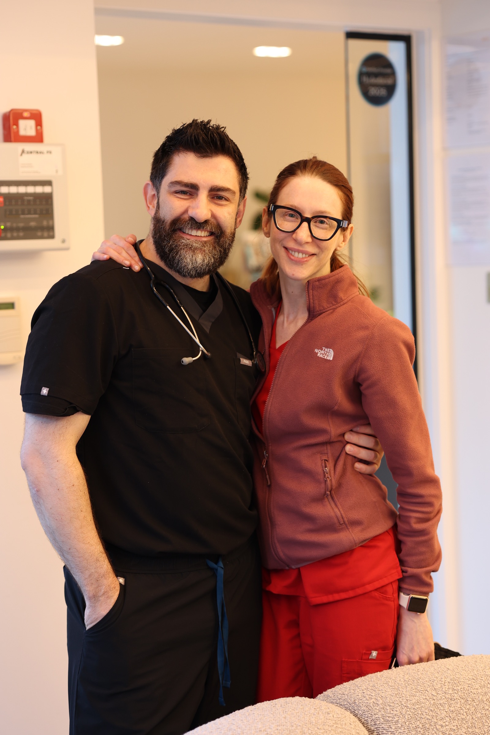 Dr Cemal Kavasogullari in black medical scrubs with a colleague
