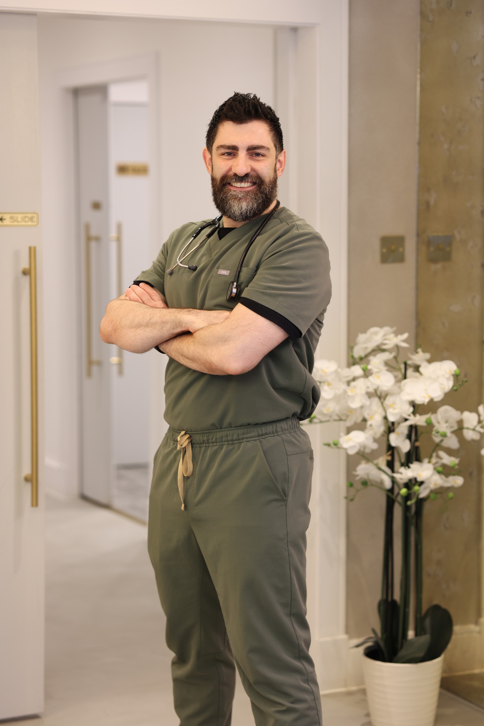 Dr Cemal Kavasogullari standing in medical scrubs