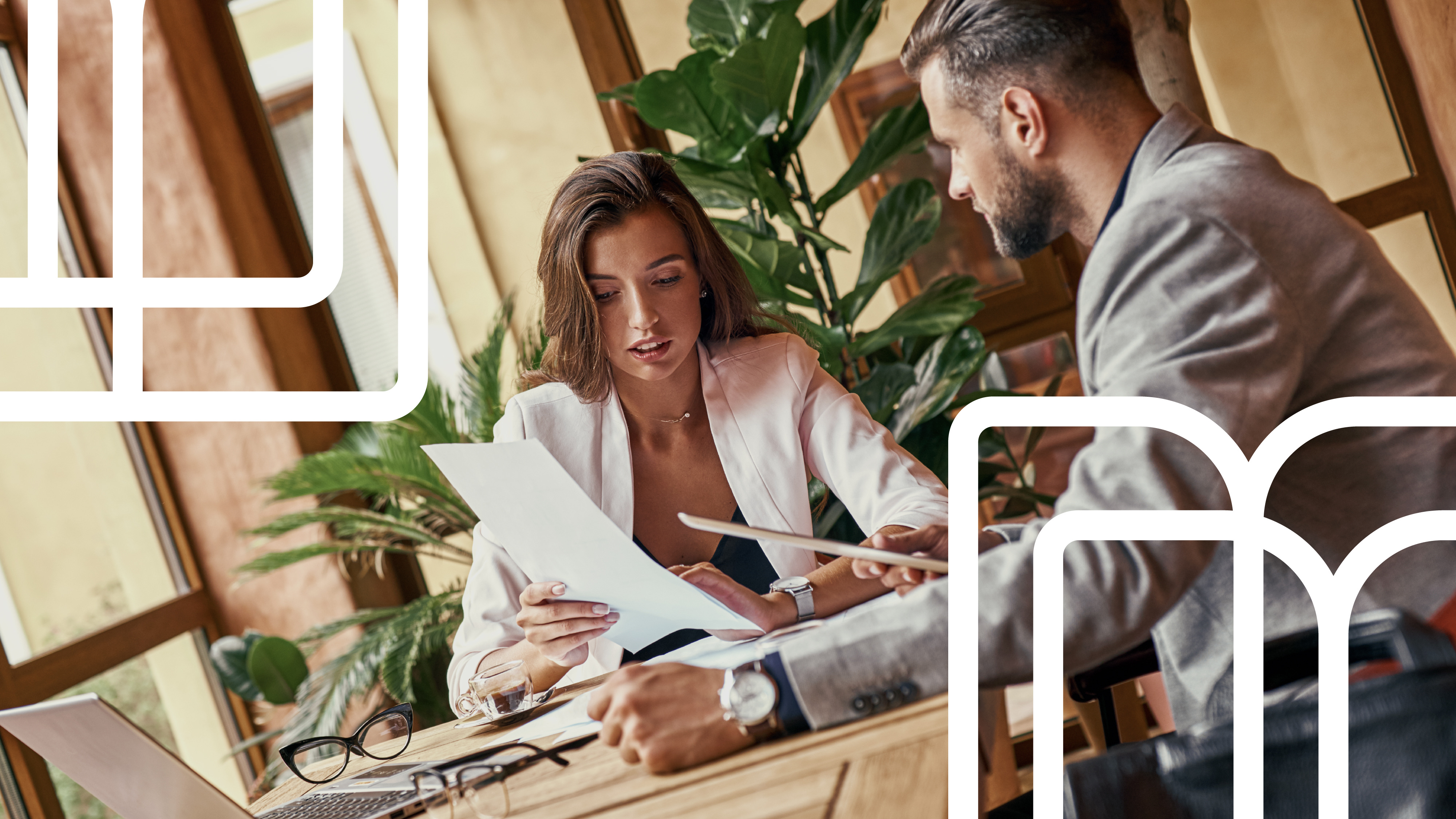 Three colleagues reviewing documents together at a bright office table