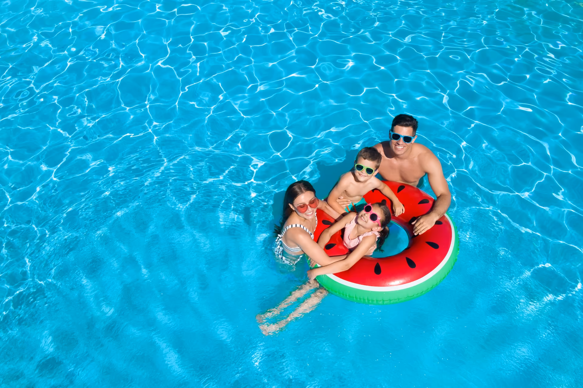 Family in pool with watermelon float