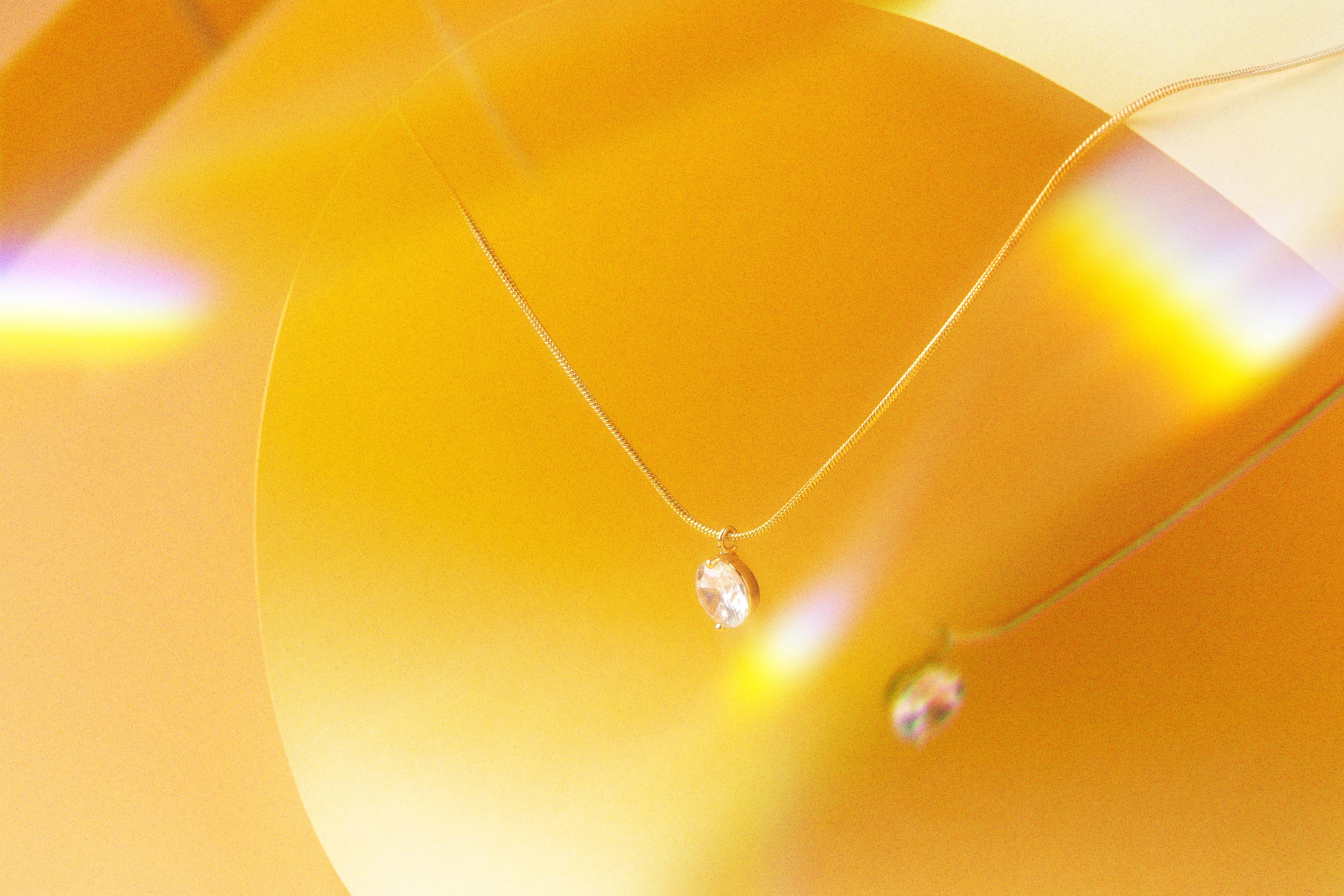 Gold necklace with a round clear pendant