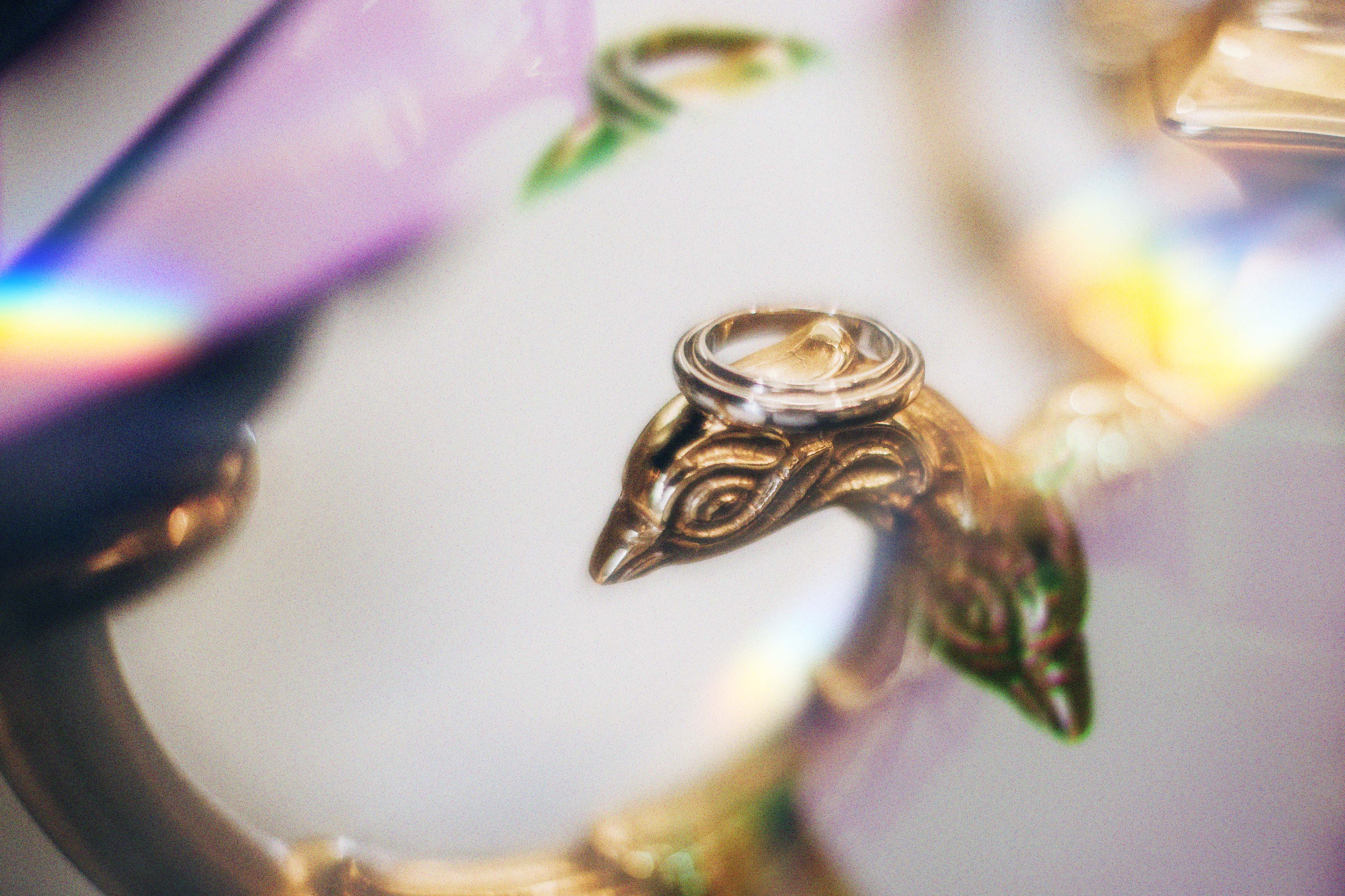 Gold bird figurine with a silver ring on its head