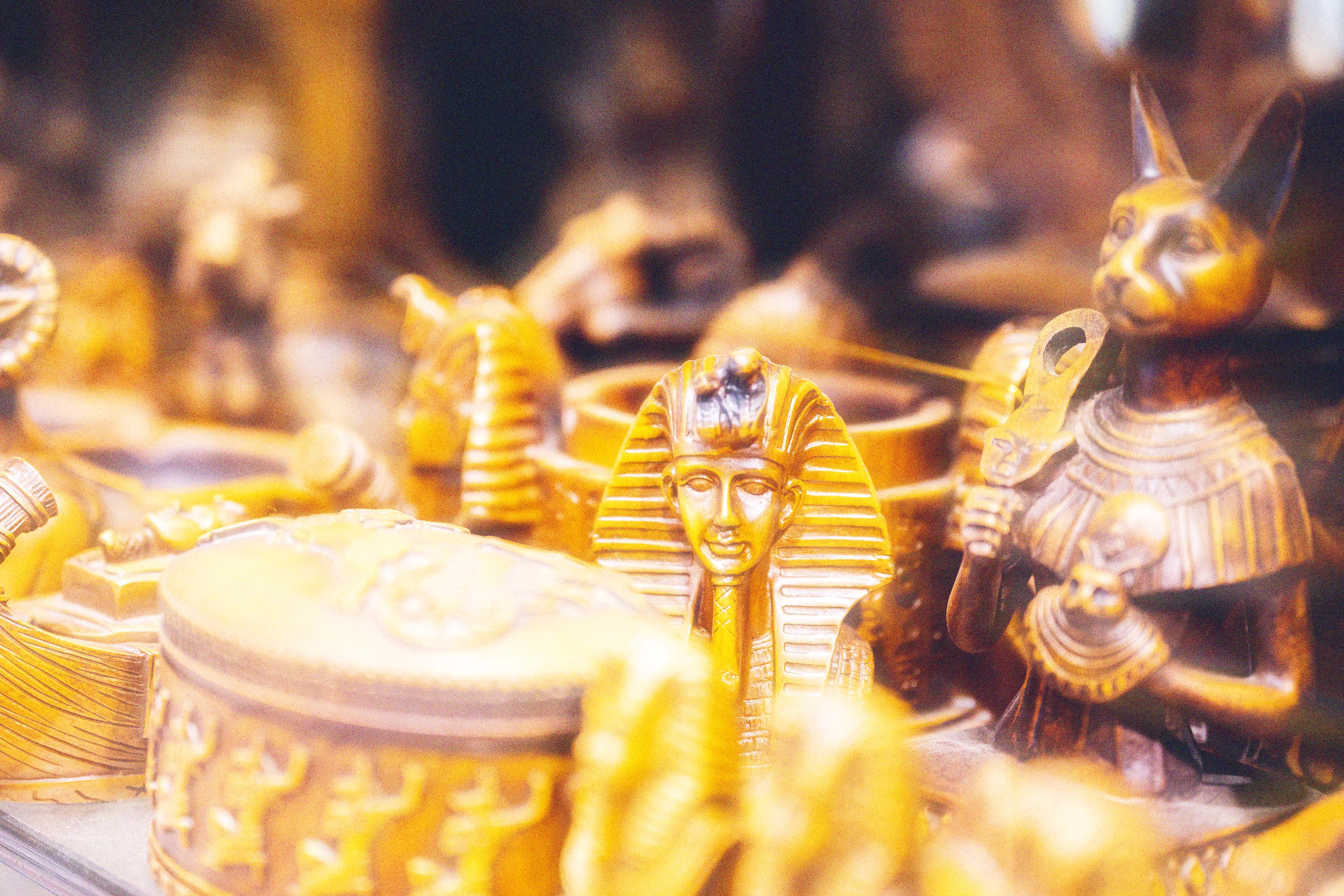 Gold Egyptian figurines, including a cat and a pharaoh bust